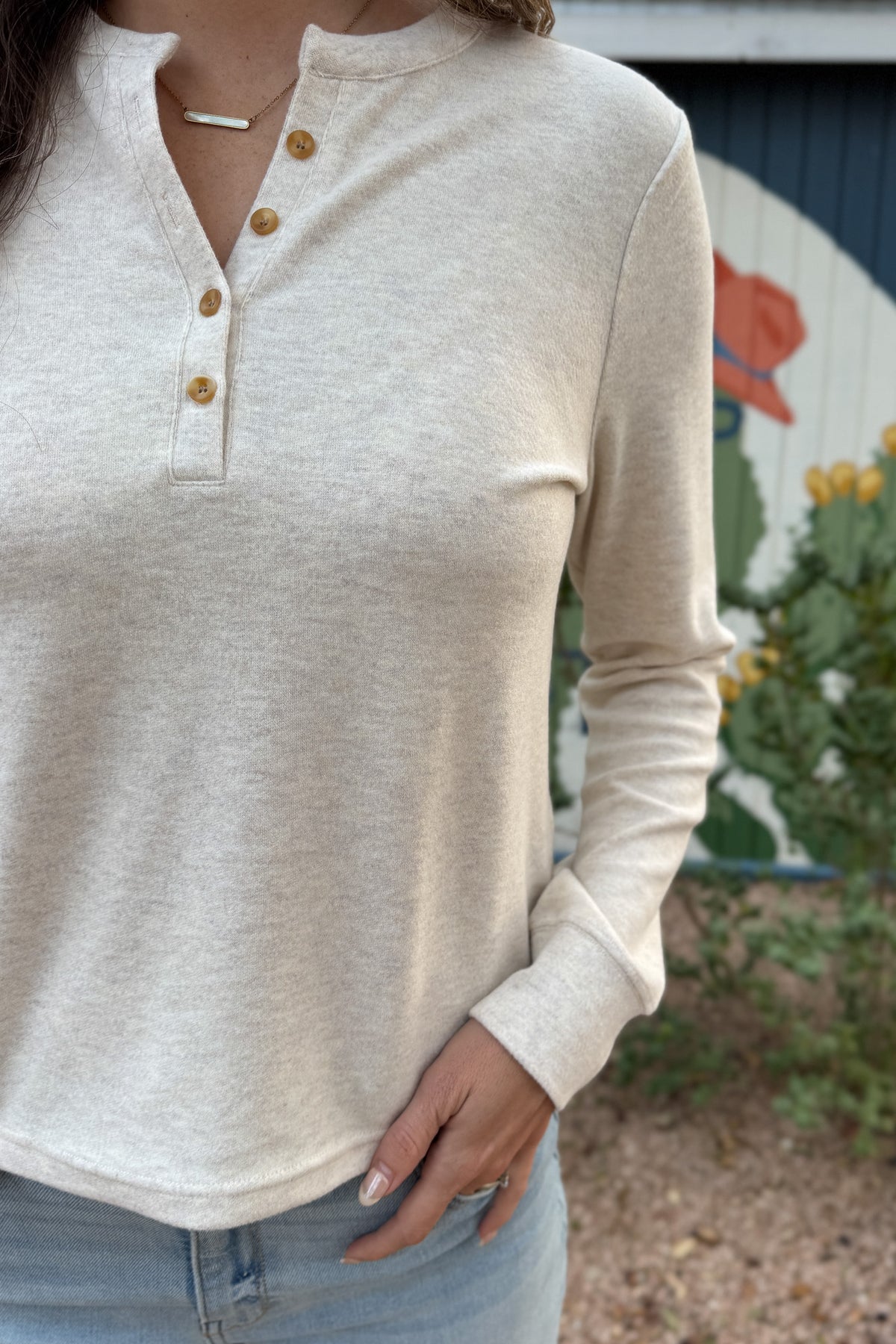 An easy everyday staple, this soft henley top blends laid-back comfort with a polished touch. Designed with a four-button neckline and subtle heathered texture, it’s the perfect piece for layering or wearing solo.