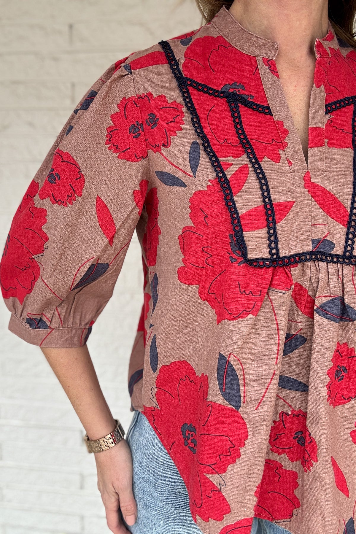 This floral blouse brings an easy, elevated feel to your everyday wardrobe. The linen-cotton blend keeps it lightweight and breathable, perfect for warm days and easy layering. The split neckline and contrast trim add just enough detail to make it feel special while staying effortless.