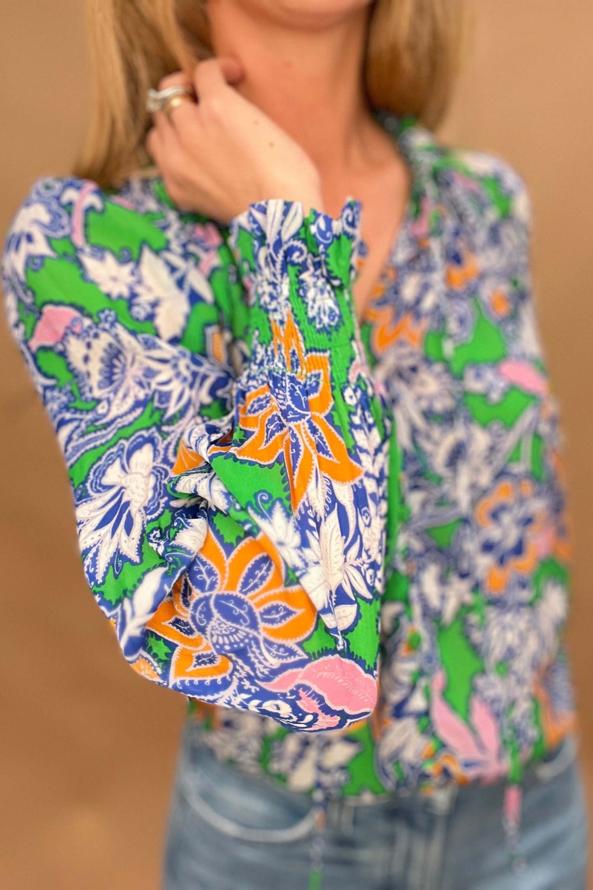 This lightweight and colorful fabric offers a playful twist with ruffled neckline and cuffs, tied neckline, and ever so slightly puffed shoulders.

The lightweight material is perfect for warmer days.&nbsp;

The fabric covered buttons, ruched detailing on the neckline &amp; cuffs adds an extra touch of elegance.