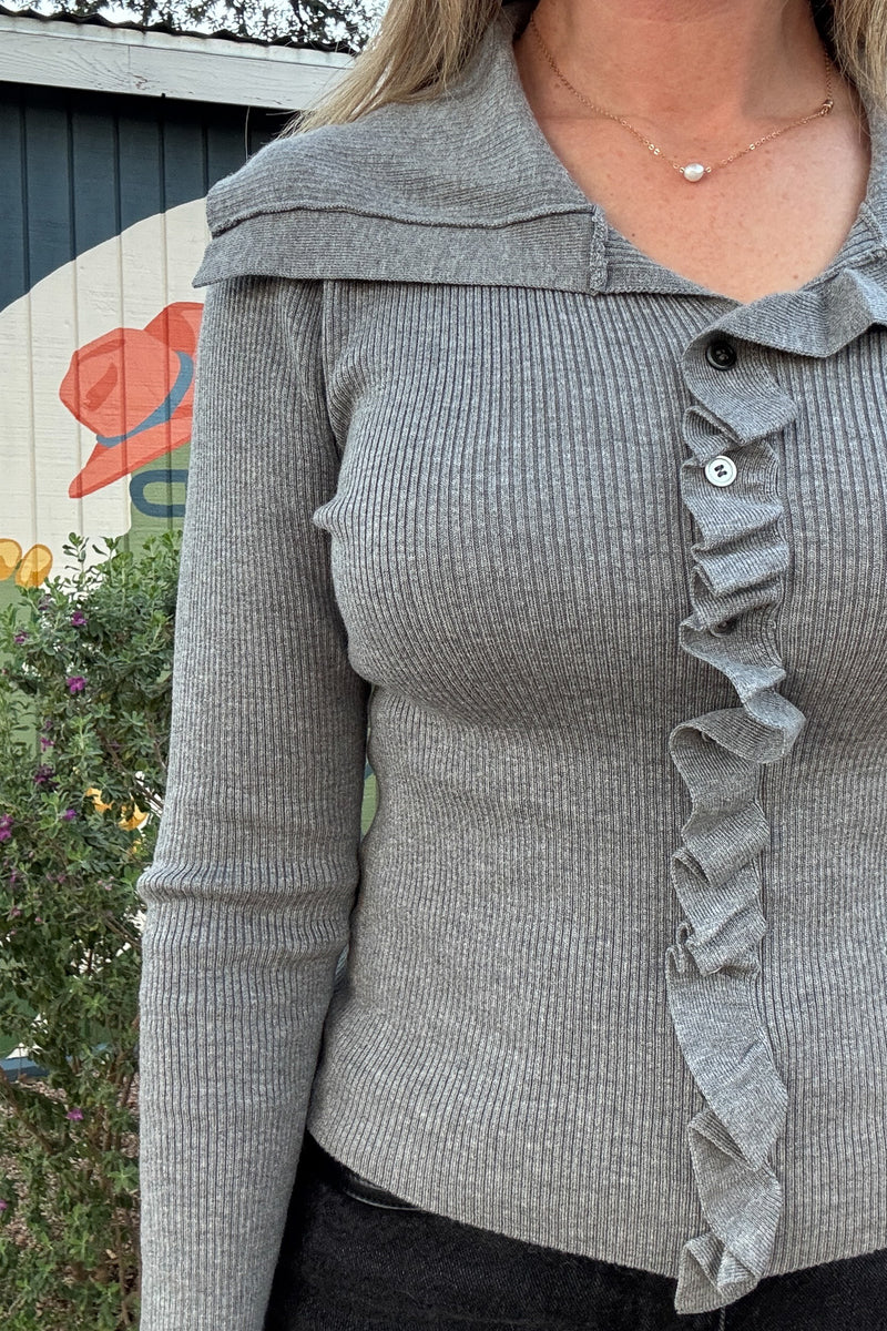 Fitted gray ribbed sweater top featuring long sleeves, a statement sailor collar, and feminine ruffle detailing down the front.