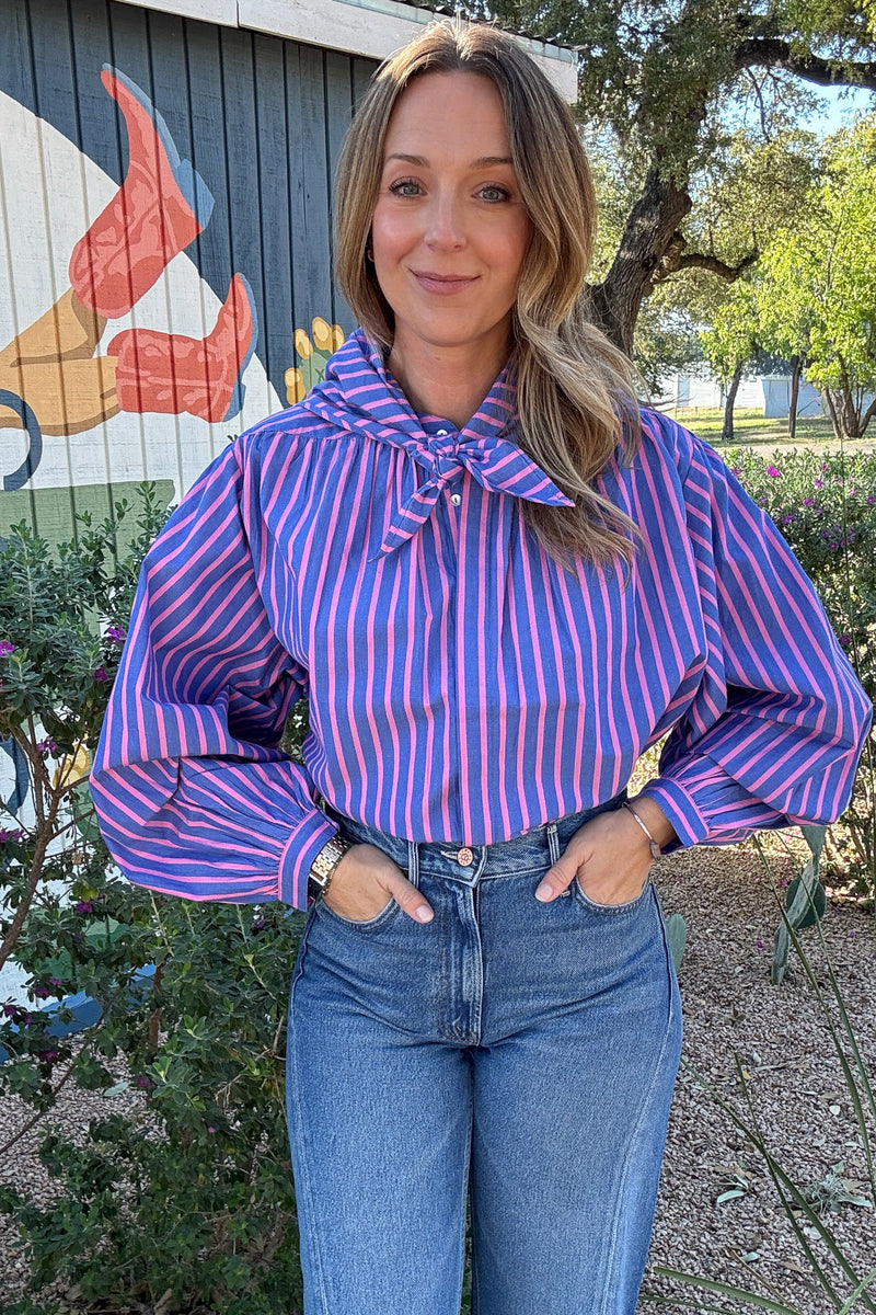 Colorful women's striped blouse featuring vertical pink and blue stripes, voluminous long sleeves, and a coordinating neck tie.