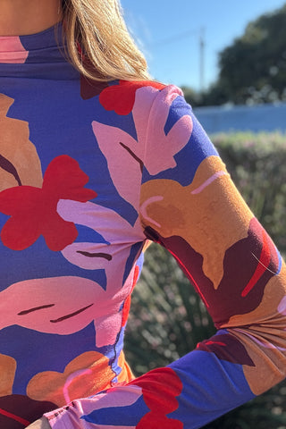 Colorful floral mock neck top for women featuring a fitted silhouette, long sleeves, and vibrant retro-inspired print.