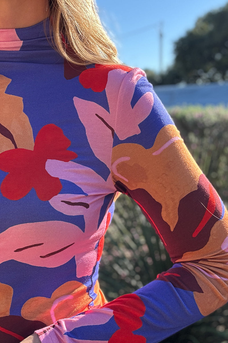Colorful floral mock neck top for women featuring a fitted silhouette, long sleeves, and vibrant retro-inspired print.