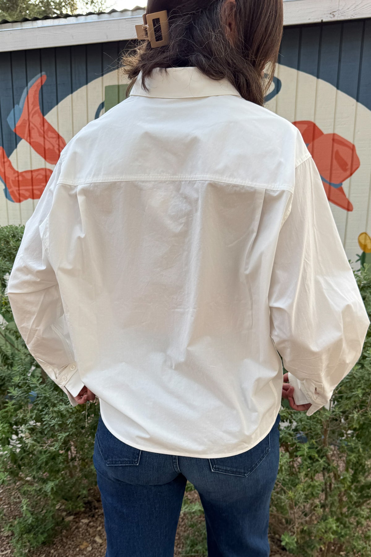 Women’s white cotton button front top with oversized pocket detail, wide button cuffs, and an effortless boxy fit.