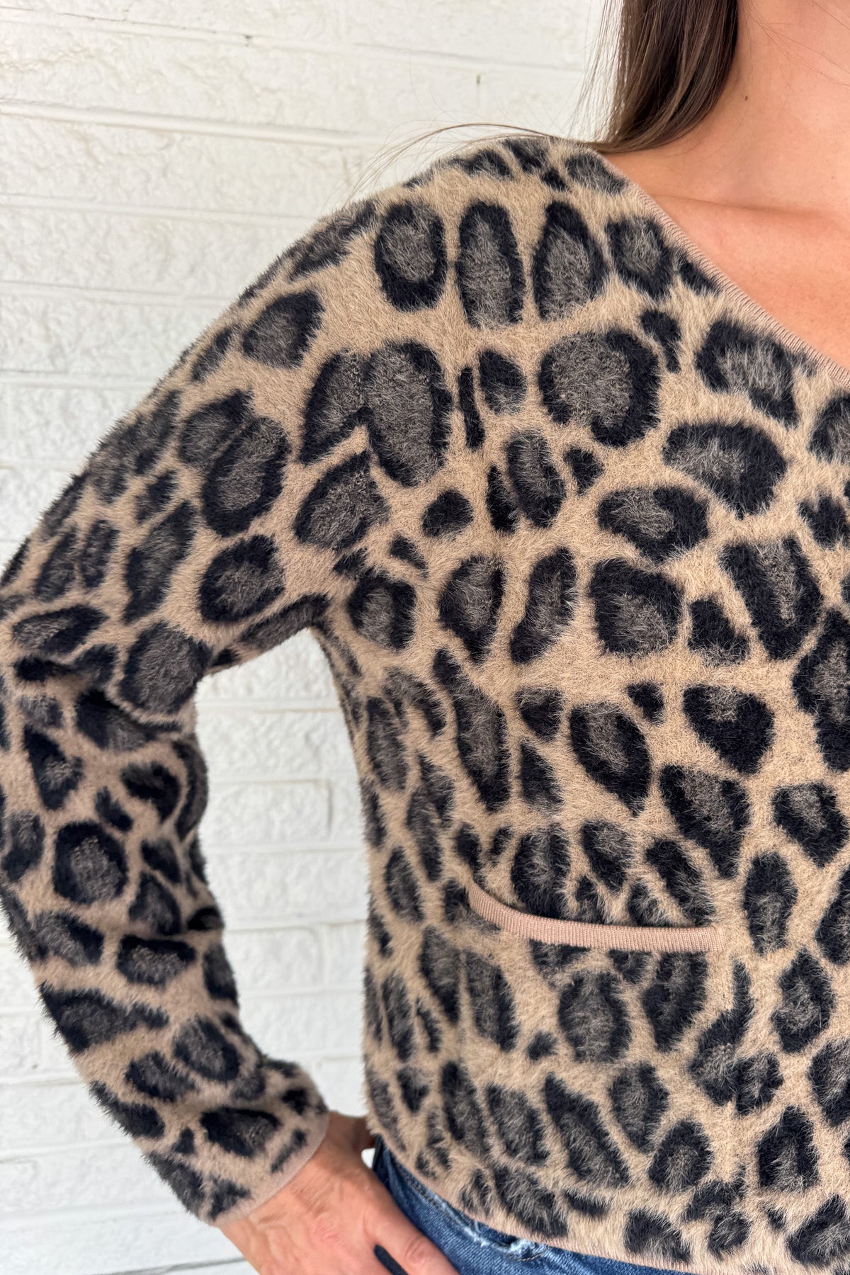 Add a playful pop to your wardrobe with this fuzzy leopard print cardigan. Made from a soft poly blend, it’s cozy with a touch of fun, featuring a button front, front pockets, and a cropped fit. A statement layer that still feels effortless for everyday wear.
