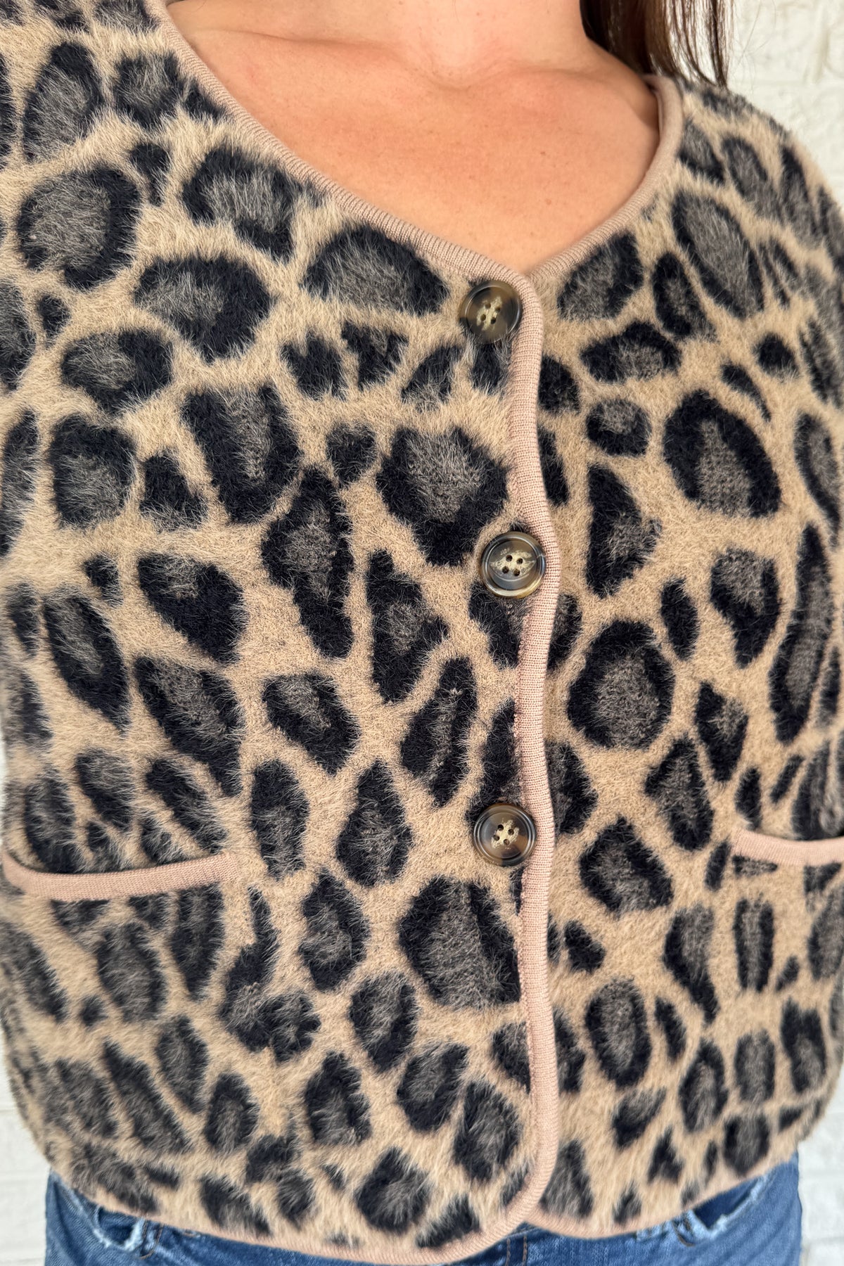 Add a playful pop to your wardrobe with this fuzzy leopard print cardigan. Made from a soft poly blend, it’s cozy with a touch of fun, featuring a button front, front pockets, and a cropped fit. A statement layer that still feels effortless for everyday wear.