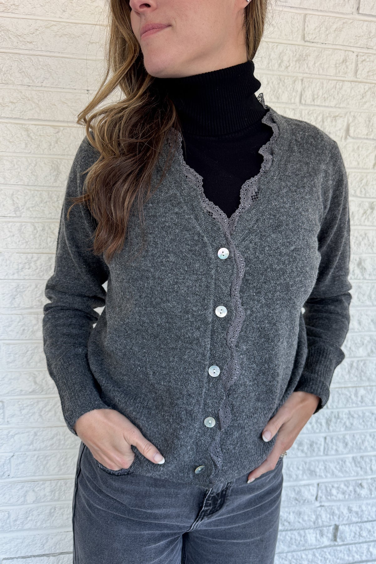 &nbsp;Knitted cardigan with feminine details. The lace trim along the neckline and button placket adds a soft, delicate touch to this everyday essential. Pearlescent buttons and scalloped edges give it a polished finish while the cozy knit keeps it comfortable.