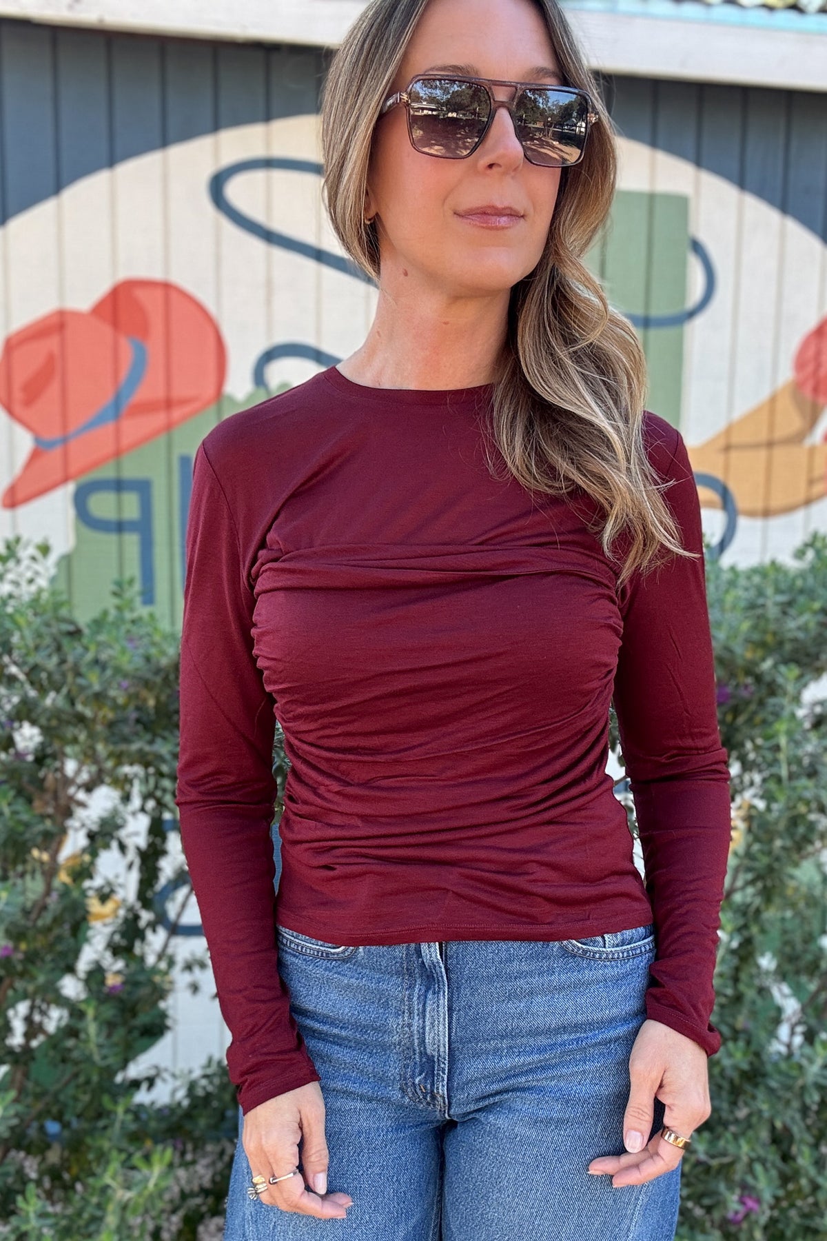 Women's burgundy long sleeve top featuring a flattering ruched bodice, crew neckline, and fitted silhouette. Shop Cotton & Cashmere Boutique.