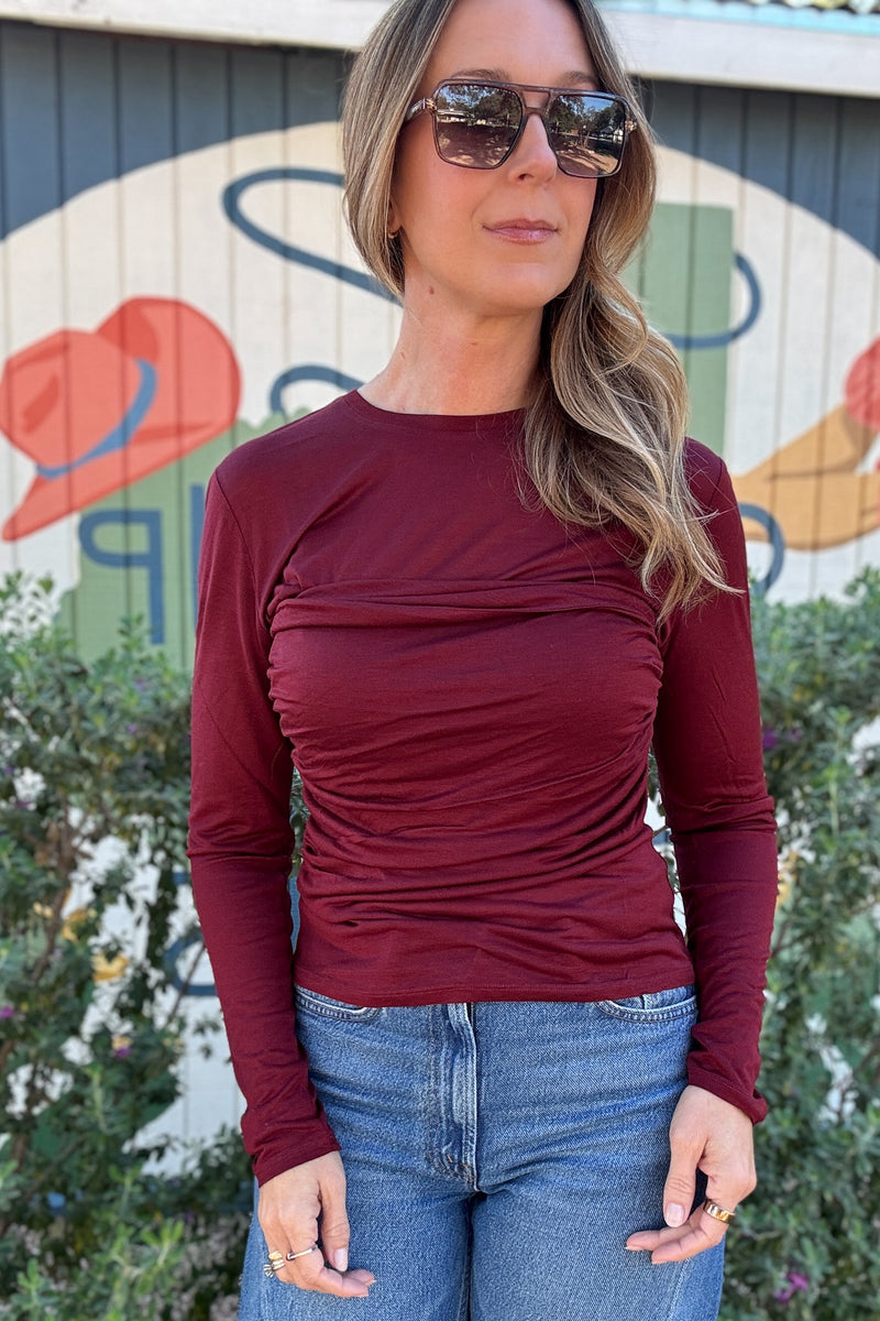 Women's burgundy long sleeve top featuring a flattering ruched bodice, crew neckline, and fitted silhouette. Shop Cotton & Cashmere Boutique.