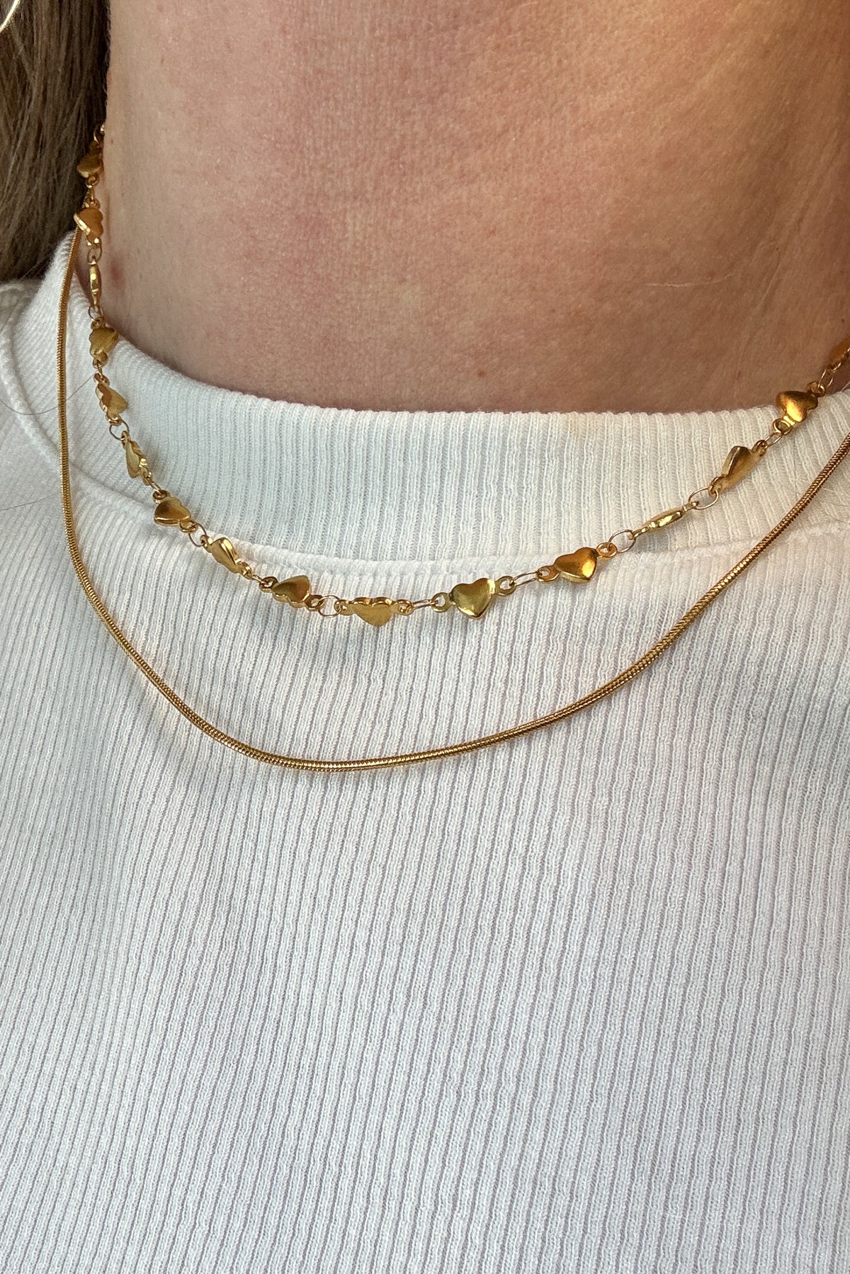 The string along necklace features a heart chain (hearts are solid on both sides), and a slim rope chain.

18k gold plated or stainless steel
water proof
double strand necklace
adjustable 14.5" - 16.5"
nickel / lead free
made with materials ethically sourced