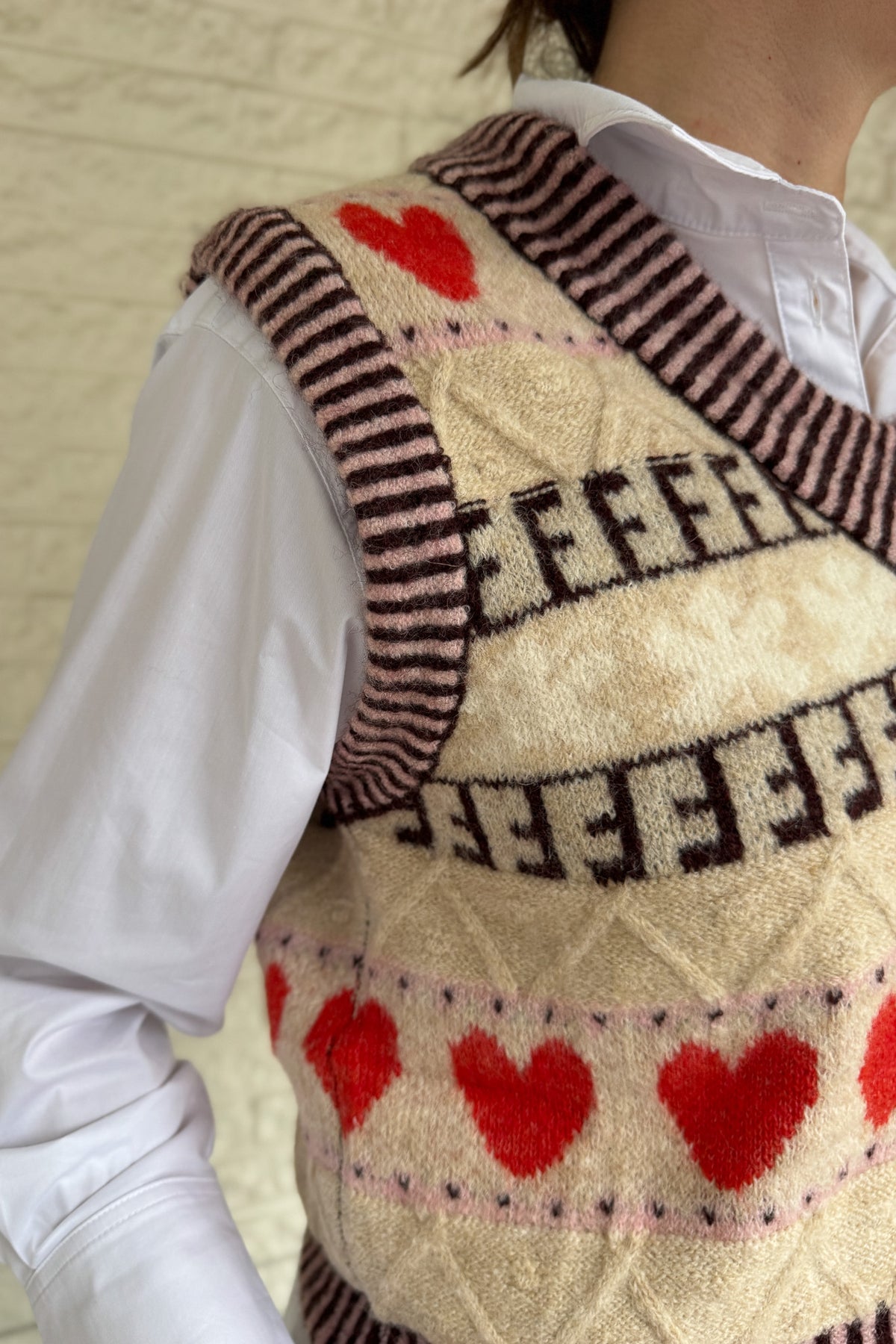 This sweater vest brings a charming, elevated touch to everyday outfits! Designed in France, it features a soft knit with a classic V neckline and a playful heart pattern that feels fun but still easy to wear. The neutral base makes it simple to style over a crisp button down or worn on its own as the seasons shift. It layers beautifully without adding bulk and gives your look a cozy, styled finish for workdays or casual plans. An easy piece to dress up denim or add interest to simple basics!