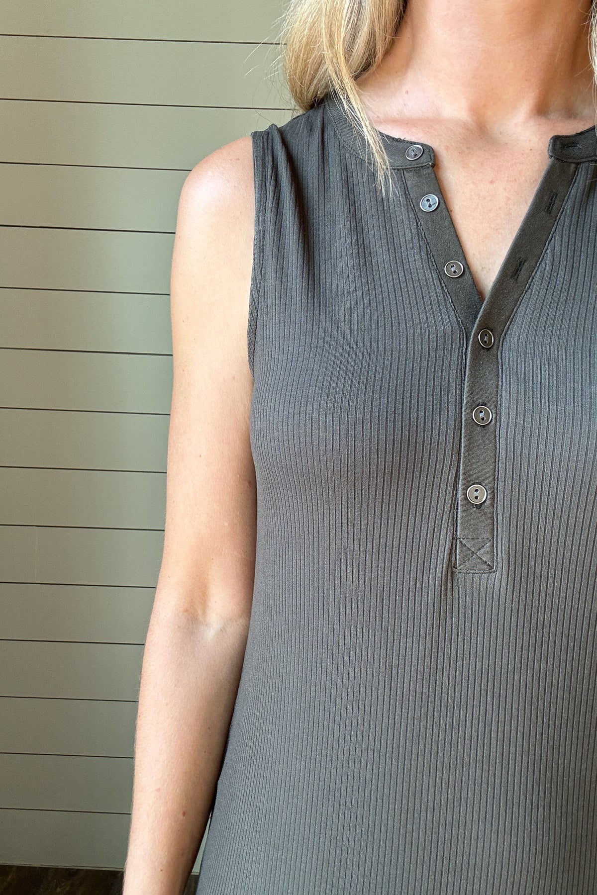 &nbsp;Effortless and flattering, this sleeveless knit dress is the perfect blend of comfort and style. Made from a soft, stretchy ribbed fabric, it skims the body without feeling tight. The henley-style button front adds a casual touch, while the midi length and side slit keep it versatile and easy to move in. Pair it with sandals for an easy day look or layer with a denim jacket for cooler evenings.