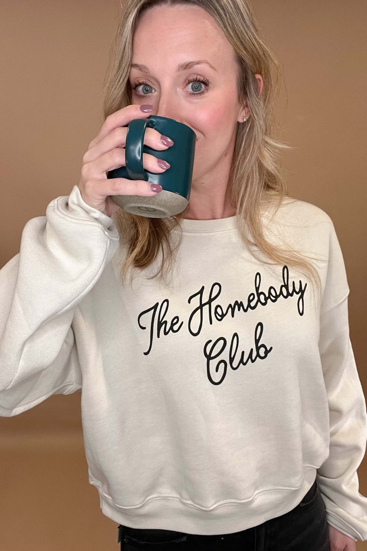 This Homebody Club Sweatshirt is a luxurious statement piece for those cozy days at home. Crafted from cozy cream fabric and black print, this sweatshirt is perfect for you or for a special someone. Wearing it will remind you that it's always homebody season.