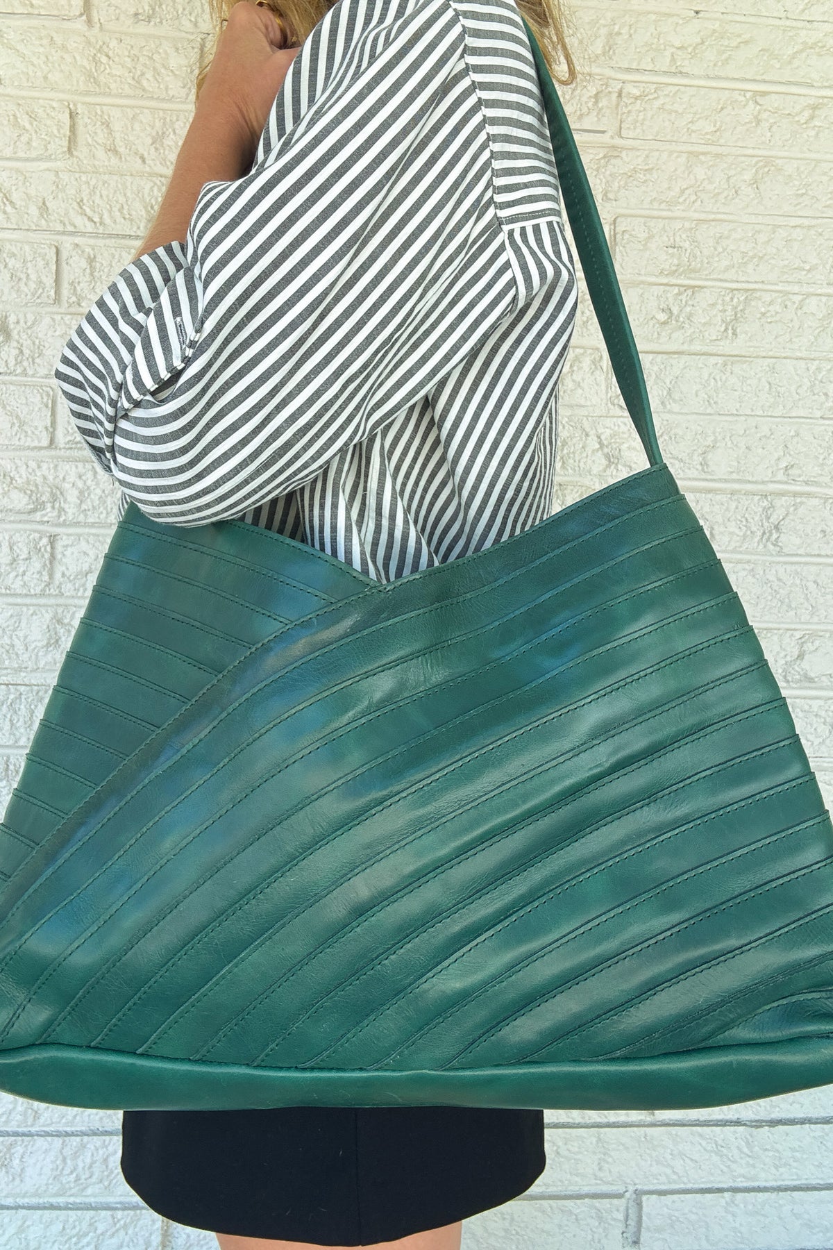 A modern, yet timeless silhouette with a generous amount of space to carry all your everyday essentials.

Created to make use of leftover strips of leather. This was one of those moments, where the challenge of creating with what the earth has already given the artist, resulted in something special. A wearable piece of art with a story.&nbsp;&nbsp;

The roomy, block printed, cotton lined interior features one zipper pocket and two slip pockets.&nbsp;