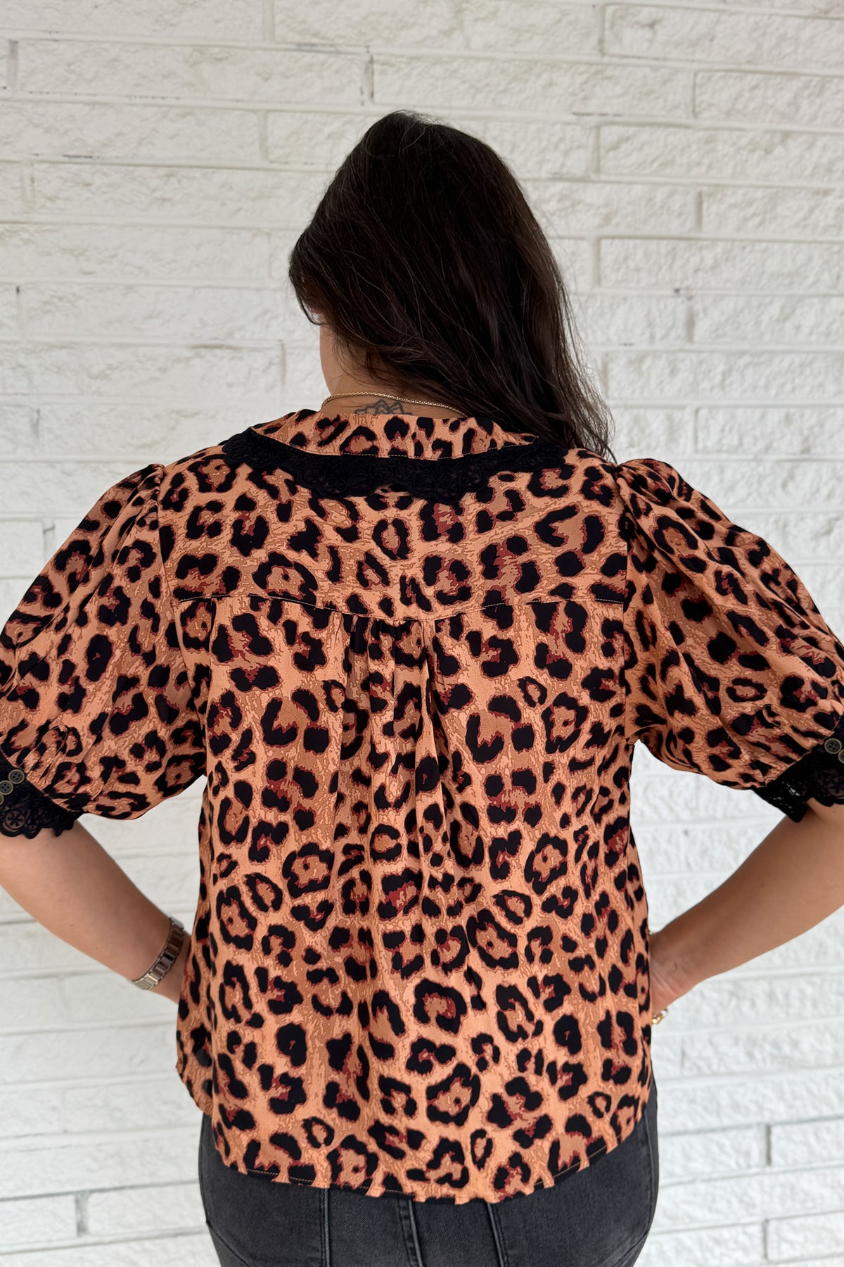 &nbsp;This leopard print blouse is bold and feminine with playful details. A black lace collar and matching lace trim on the puff sleeves give this classic print a chic update. Lightweight and easy to wear, it’s perfect for dressing up denim or pairing with tailored pants.