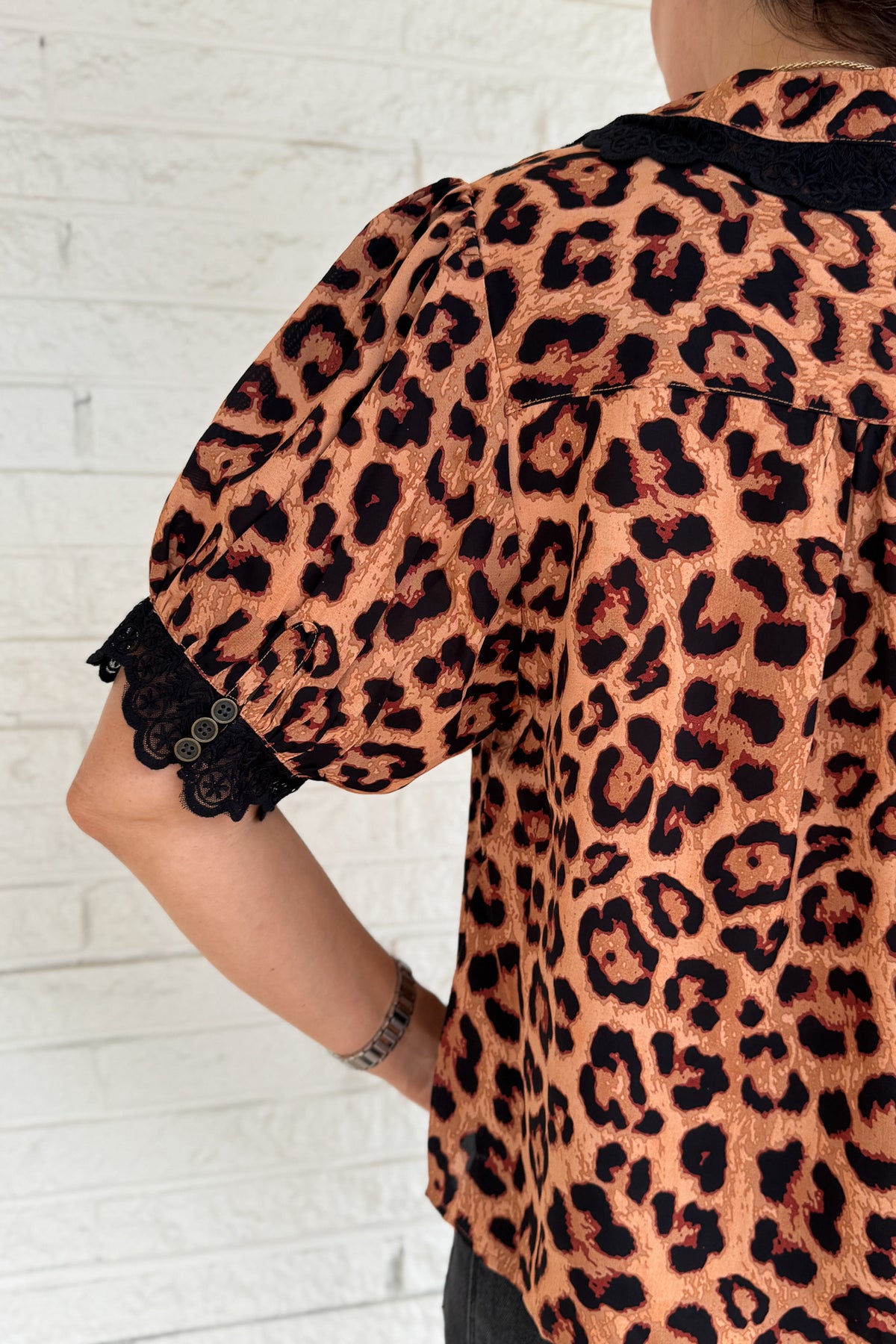 &nbsp;This leopard print blouse is bold and feminine with playful details. A black lace collar and matching lace trim on the puff sleeves give this classic print a chic update. Lightweight and easy to wear, it’s perfect for dressing up denim or pairing with tailored pants.