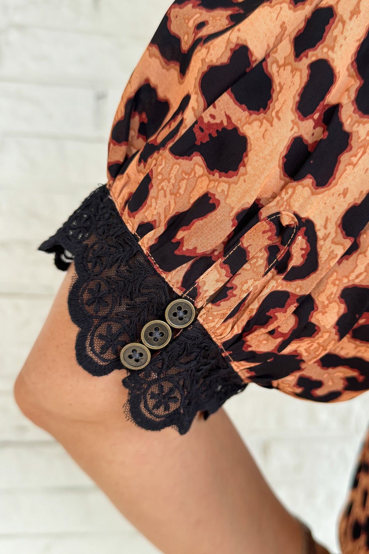 &nbsp;This leopard print blouse is bold and feminine with playful details. A black lace collar and matching lace trim on the puff sleeves give this classic print a chic update. Lightweight and easy to wear, it’s perfect for dressing up denim or pairing with tailored pants.