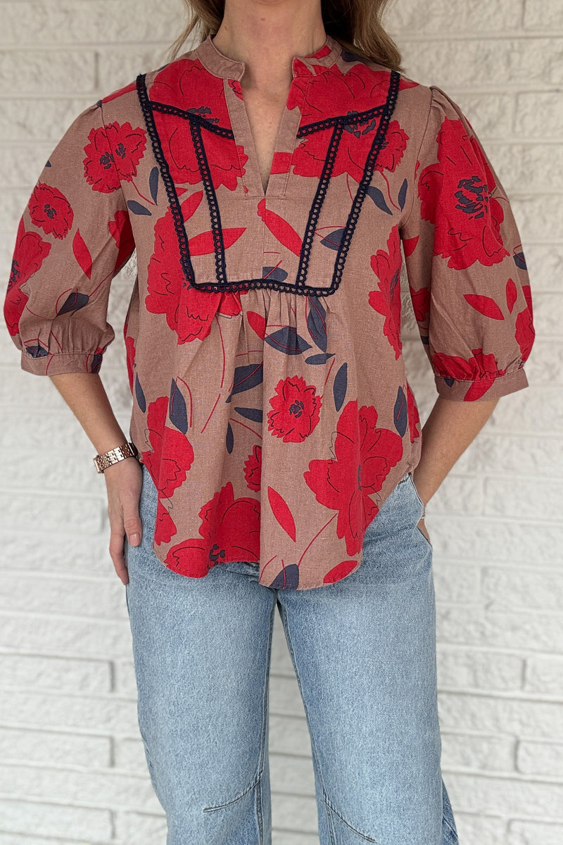 This floral blouse brings an easy, elevated feel to your everyday wardrobe. The linen-cotton blend keeps it lightweight and breathable, perfect for warm days and easy layering. The split neckline and contrast trim add just enough detail to make it feel special while staying effortless. Women's fashion boutique Blanco Texas Johnson City Texas