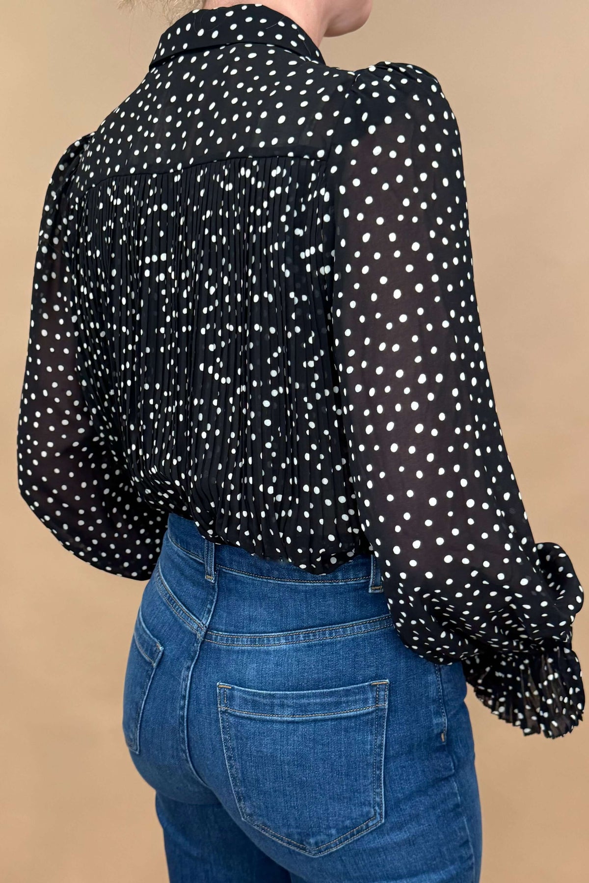 Introducing the Louka Blouse, designed in France by Suncoo. This gorgeous blouse features lightweight fabric, pleating on the arms and bodice, removable neck tie, and ruffled cuffs. With beautiful polka dot detailing, it's a timeless and classic addition to your wardrobe.