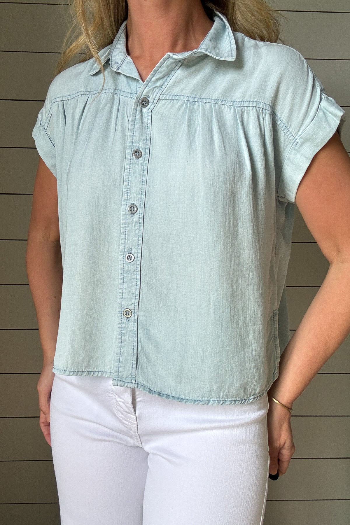 This button-front Tencel top is an easy grab for everyday style. Soft, breathable, and lightweight, it drapes beautifully and gives a polished look without any effort. Designed with a classic collar, full front buttons, and subtle side slits for a relaxed fit, it moves with you and hits just at the hips for a flattering finish. 