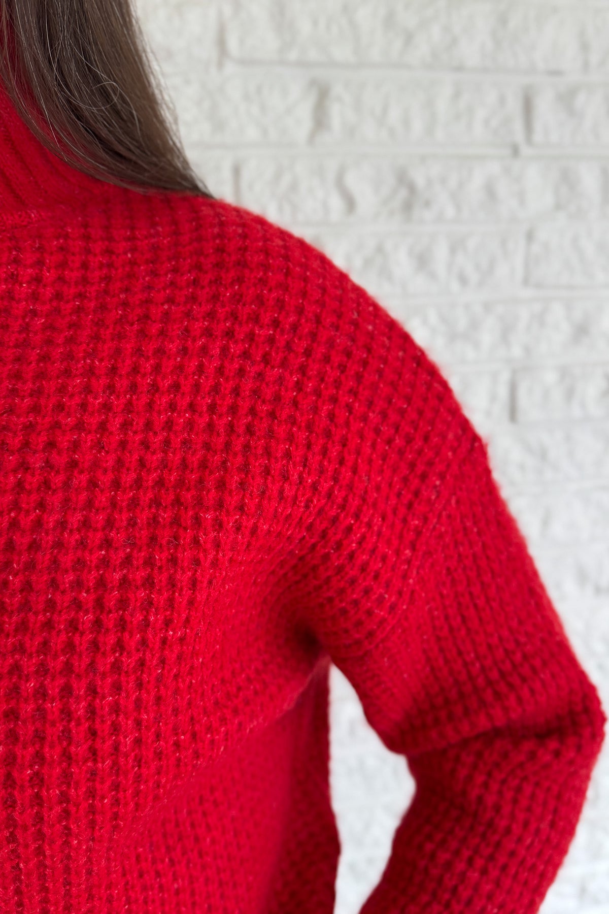 This bold red oversized sweater brings warmth and style together in one easy piece. Knitted in a soft, textured “square” weave, it features a cozy stand-up collar and ribbed finishes that keep the look clean and structured. Perfect for pairing with denim or a skirt for effortless everyday wear.
