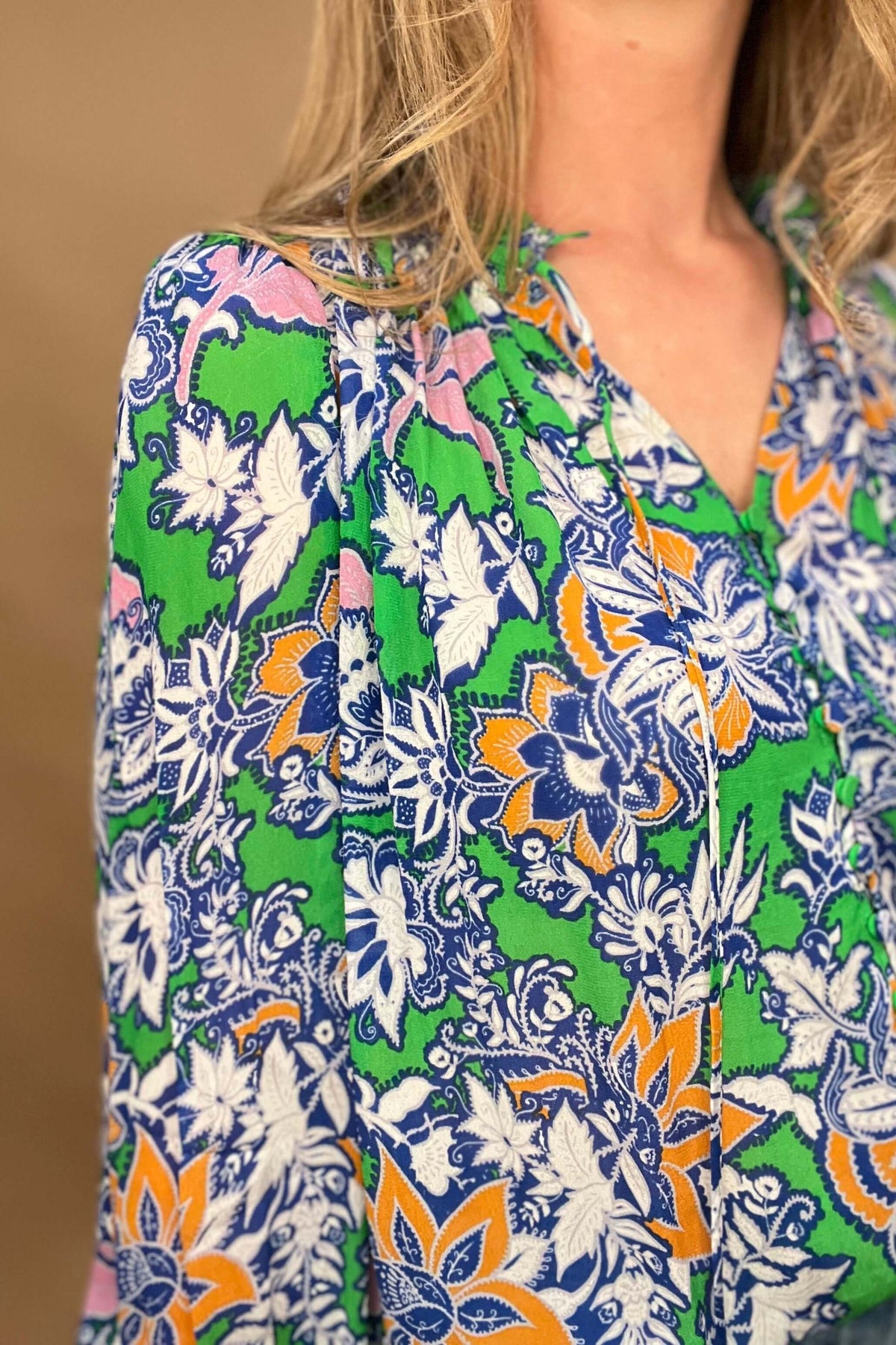 This lightweight and colorful fabric offers a playful twist with ruffled neckline and cuffs, tied neckline, and ever so slightly puffed shoulders.

The lightweight material is perfect for warmer days.&nbsp;

The fabric covered buttons, ruched detailing on the neckline &amp; cuffs adds an extra touch of elegance.