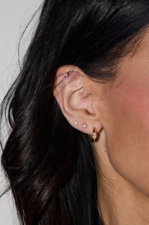 Three-pair gold earring set by Nickel & Suede with dainty studs and huggie hoops, available at Cotton & Cashmere women's boutique in Blanco, Texas.