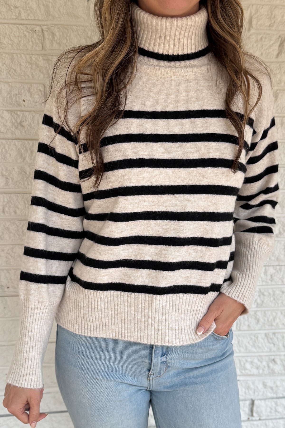 A modern take on the classic striped sweater, this cozy turtleneck features a chic open-back detail for an unexpected twist. Soft and warm with a relaxed fit, it’s an easy statement piece that pairs perfectly with denim or trousers for effortless style.