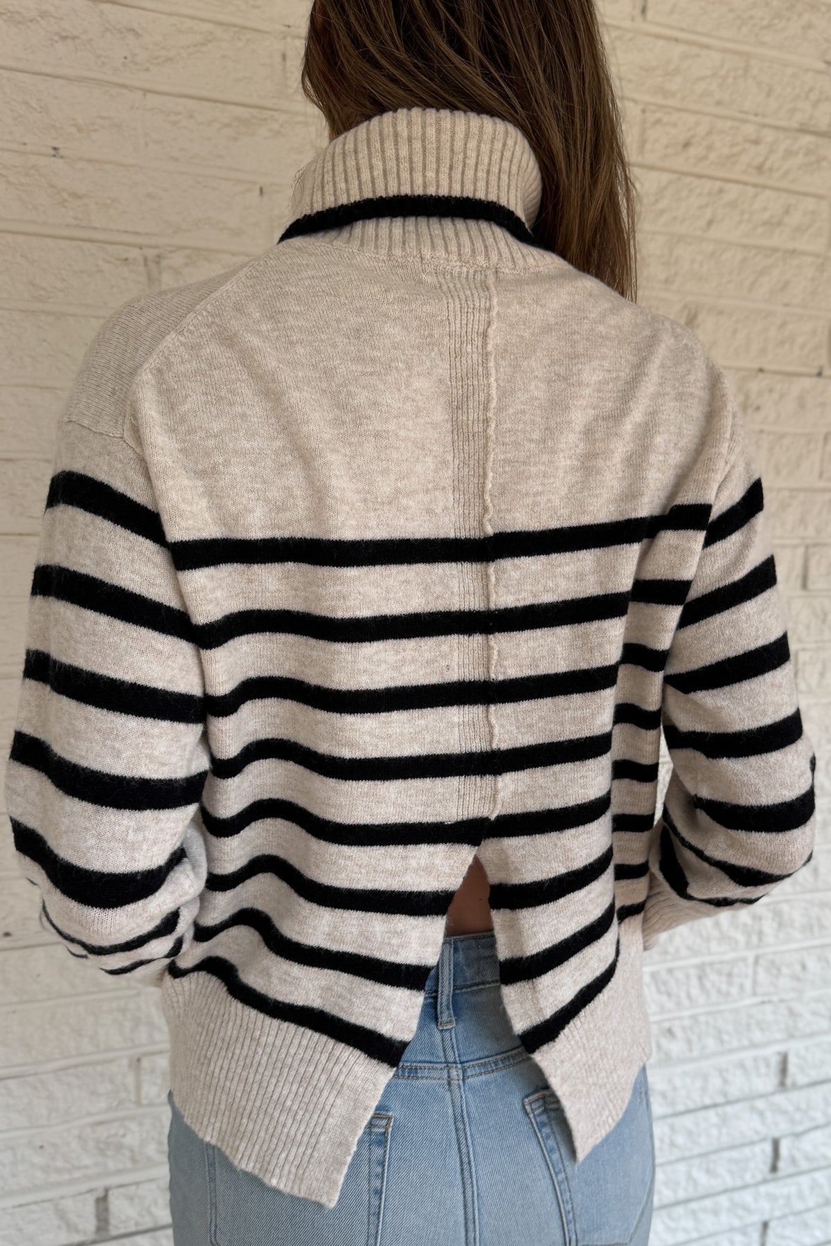 A modern take on the classic striped sweater, this cozy turtleneck features a chic open-back detail for an unexpected twist. Soft and warm with a relaxed fit, it’s an easy statement piece that pairs perfectly with denim or trousers for effortless style.