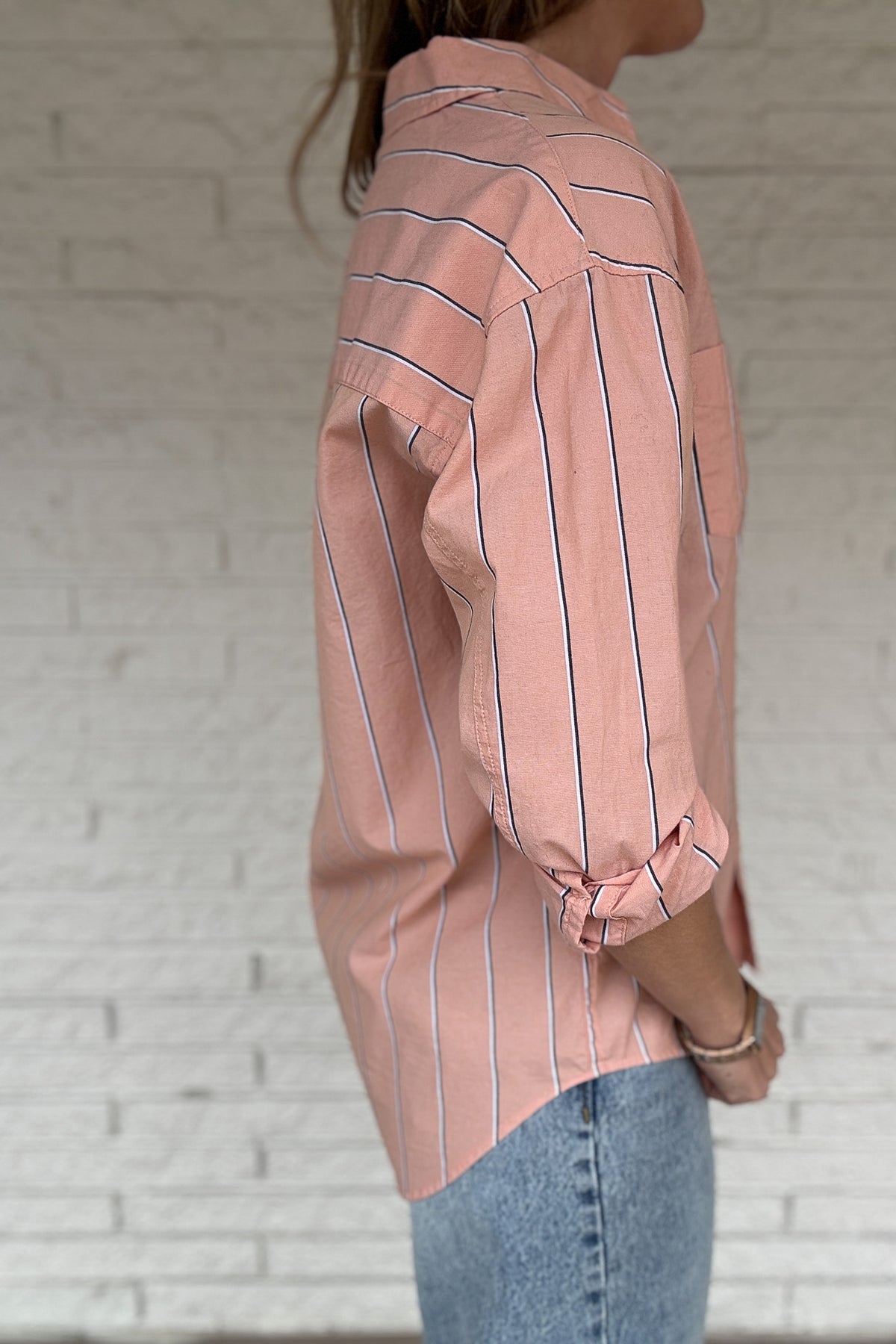This striped button-down is an easy, everyday staple you’ll reach for on repeat. Made from breathable 100% cotton, it has a relaxed feel with a polished look that works tucked, tied, or worn open over a tee. The peach tone and vertical stripe keep it flattering and effortless from workdays to weekends.

Key Features