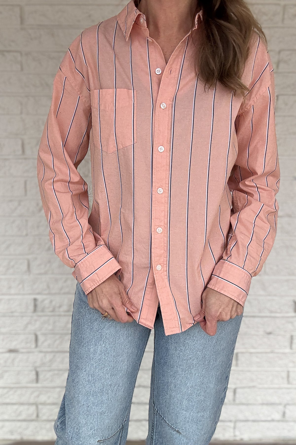 This striped button-down is an easy, everyday staple you’ll reach for on repeat. Made from breathable 100% cotton, it has a relaxed feel with a polished look that works tucked, tied, or worn open over a tee. The peach tone and vertical stripe keep it flattering and effortless from workdays to weekends.

Key Features