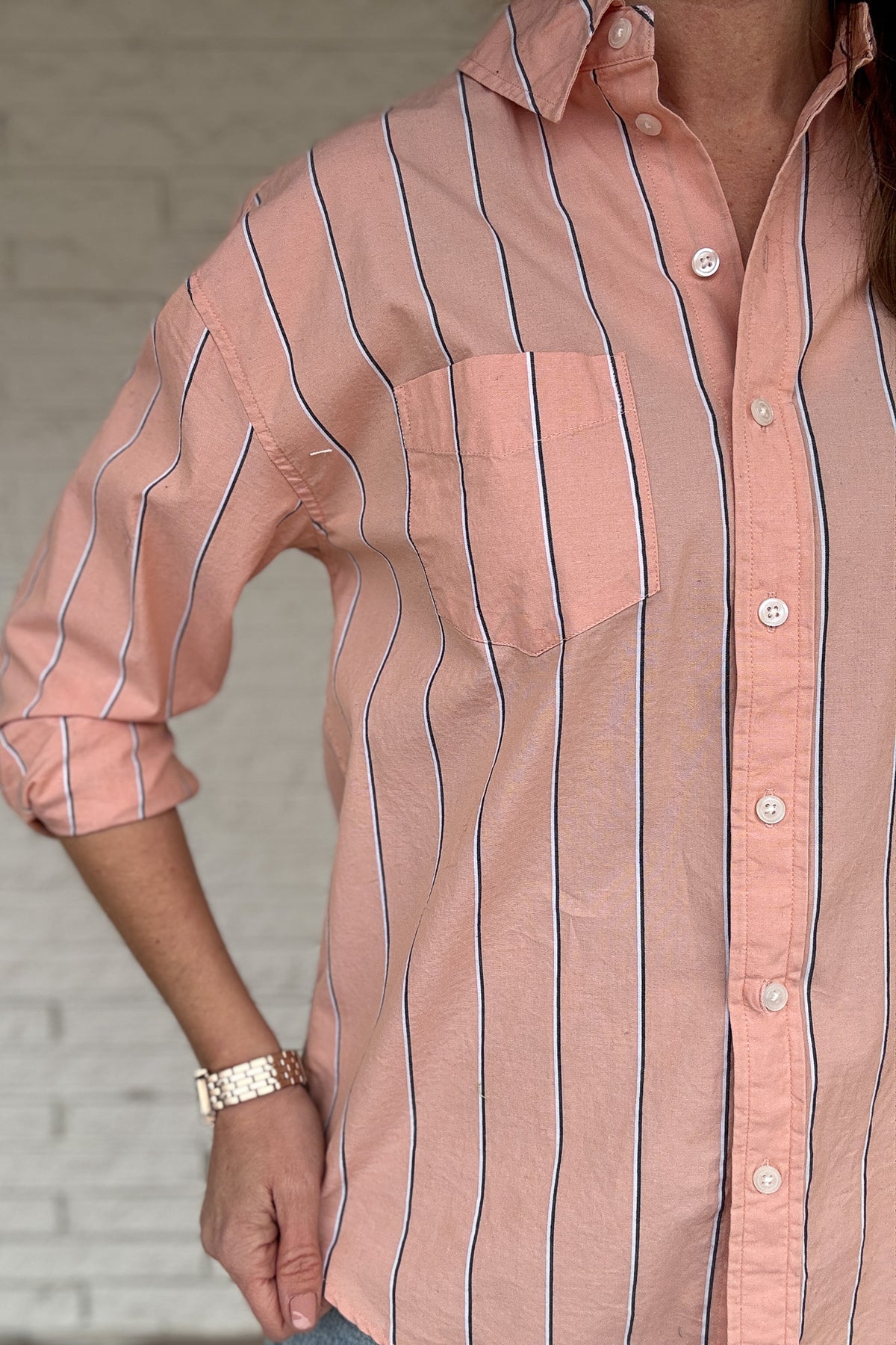 This striped button-down is an easy, everyday staple you’ll reach for on repeat. Made from breathable 100% cotton, it has a relaxed feel with a polished look that works tucked, tied, or worn open over a tee. The peach tone and vertical stripe keep it flattering and effortless from workdays to weekends.

Key Features