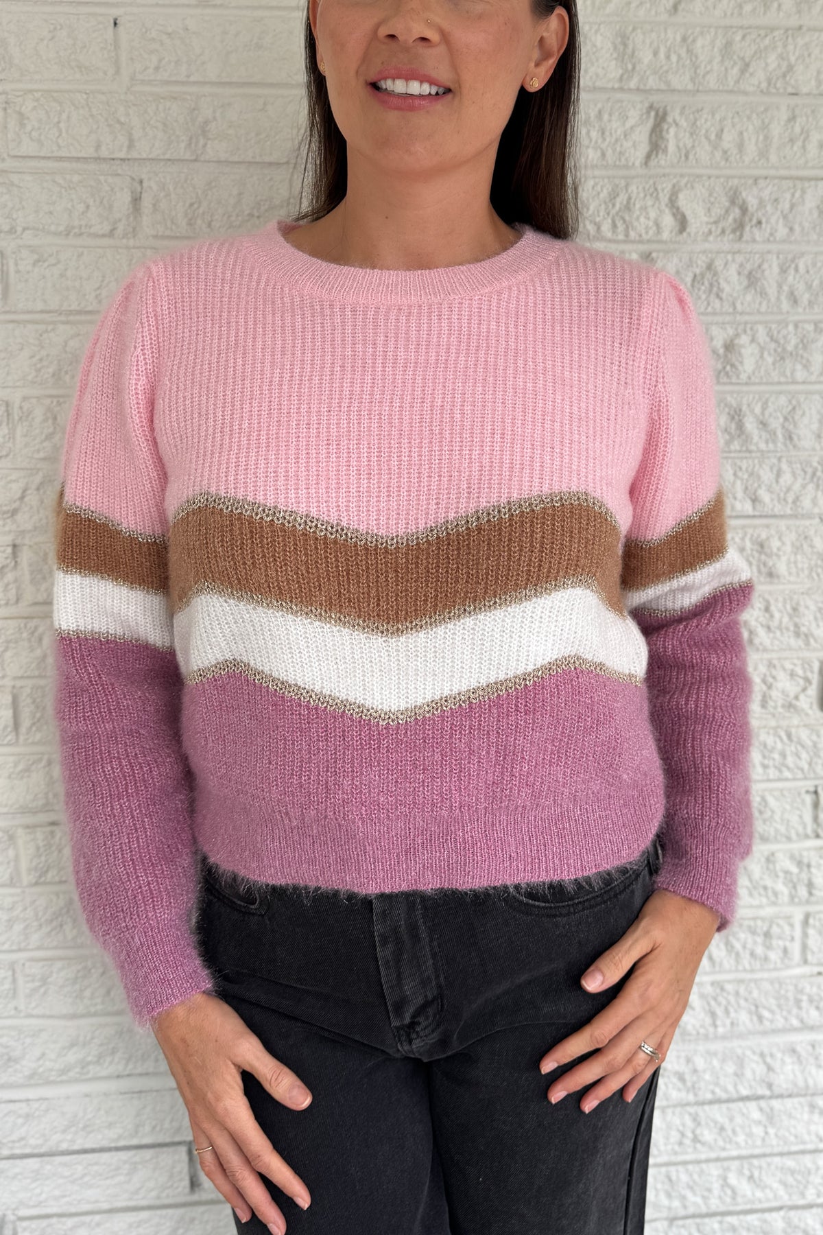 Soft and playful, this zigzag striped sweater adds a cheerful pop of color to your fall lineup. Designed with subtle shoulder gathers and a touch of shimmer in the thread, it blends comfort with a hint of fun. The mix of pink, ivory, and taupe tones makes it an easy piece to dress up or keep casual.