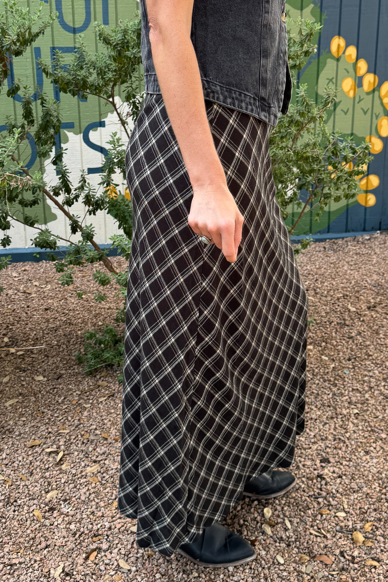 Black plaid lined maxi skirt styled with a denim vest and black flats, available at Cotton & Cashmere in Blanco, Texas.