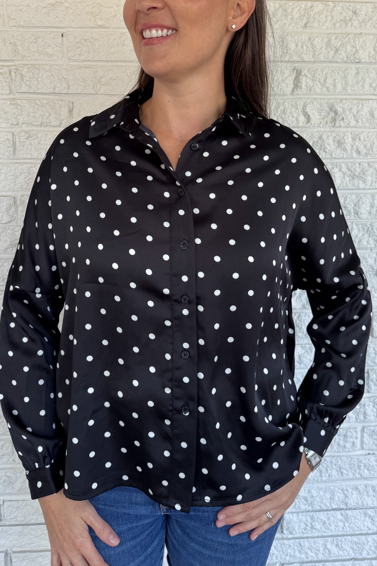A timeless polka dot blouse that blends classic style with everyday wearability. The soft poly blend drapes beautifully, while the button-down front and collared neckline keep it polished. Perfect for pairing with denim or dressing up for work.