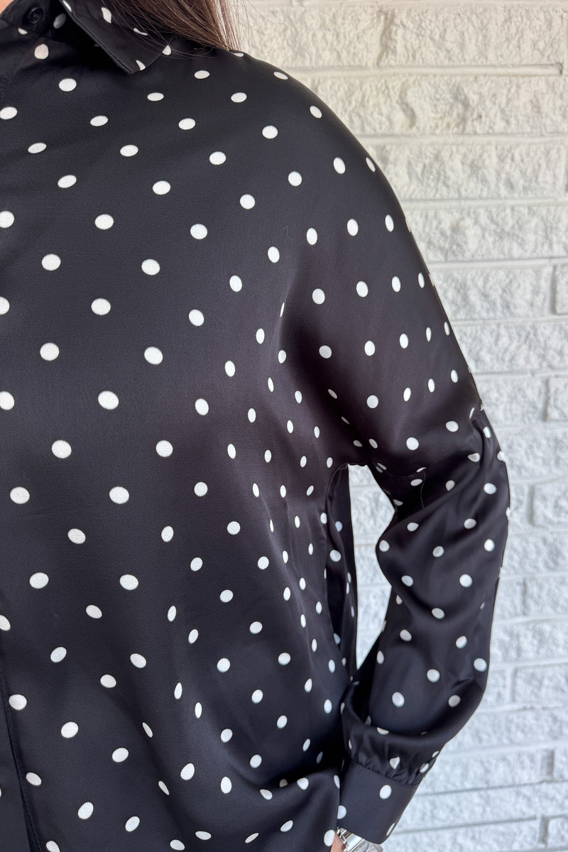 A timeless polka dot blouse that blends classic style with everyday wearability. The soft poly blend drapes beautifully, while the button-down front and collared neckline keep it polished. Perfect for pairing with denim or dressing up for work.