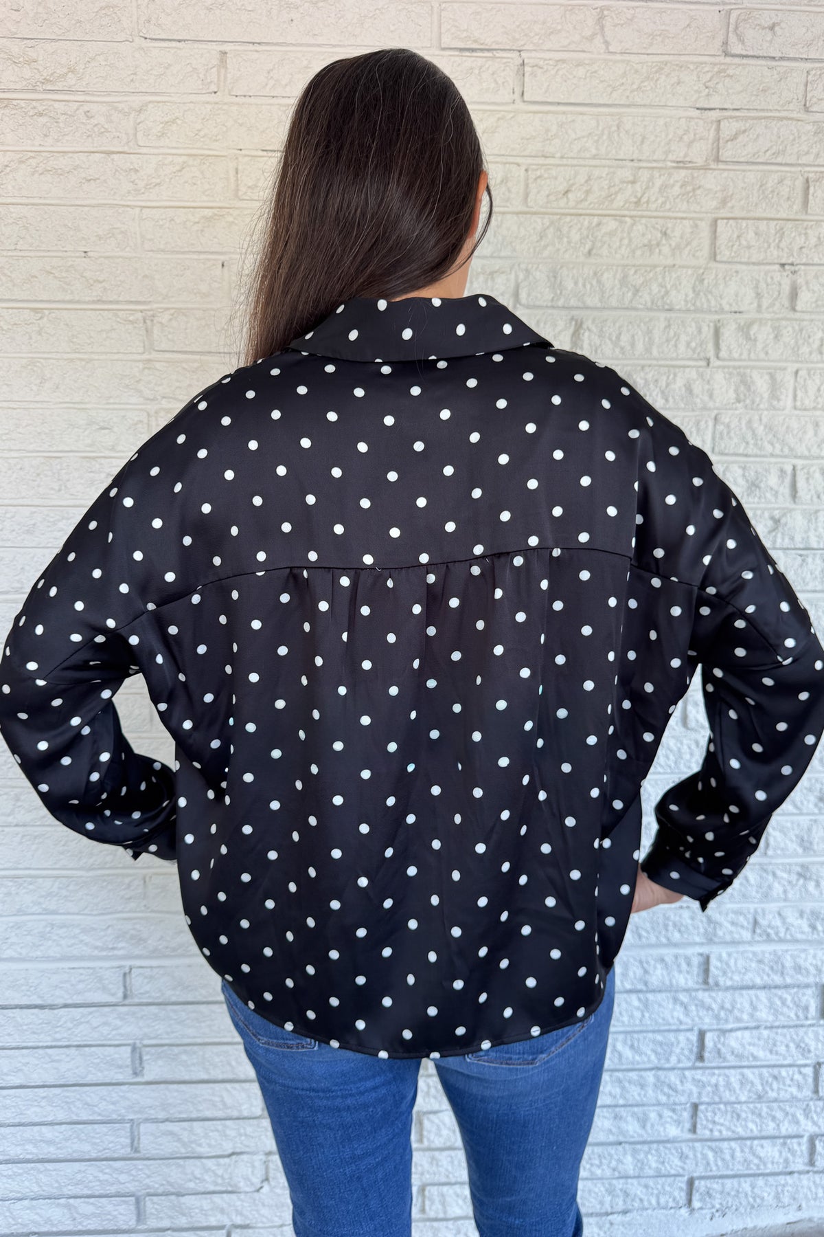 A timeless polka dot blouse that blends classic style with everyday wearability. The soft poly blend drapes beautifully, while the button-down front and collared neckline keep it polished. Perfect for pairing with denim or dressing up for work.