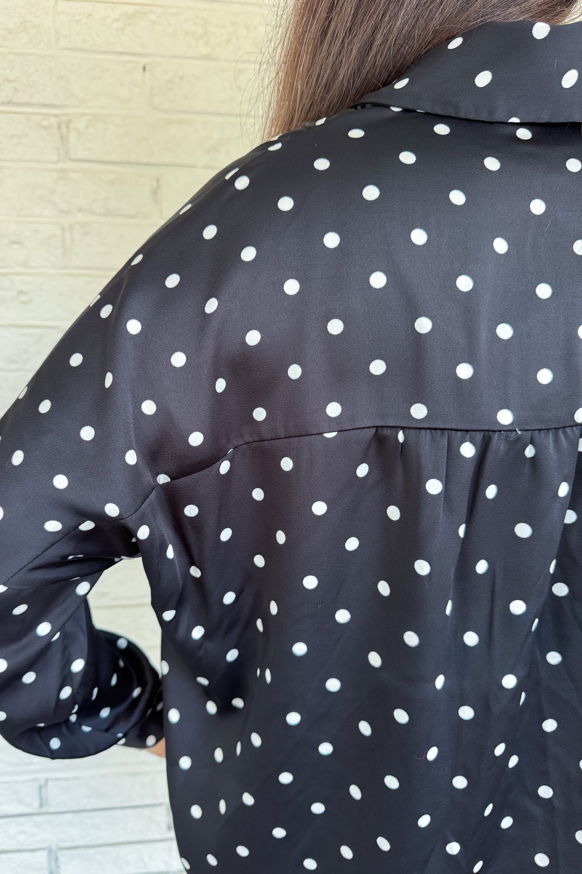 A timeless polka dot blouse that blends classic style with everyday wearability. The soft poly blend drapes beautifully, while the button-down front and collared neckline keep it polished. Perfect for pairing with denim or dressing up for work.