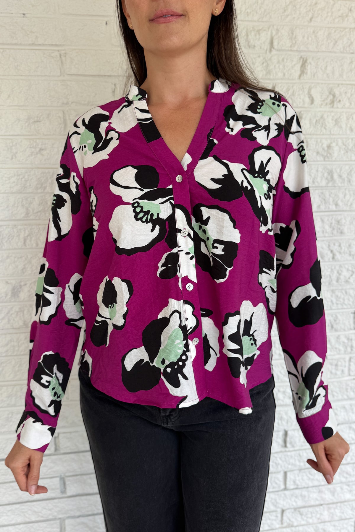 Designed in Spain, this bold floral blouse makes a statement with its vibrant magenta base and oversized poppy print. The lightweight viscose blend drapes beautifully, giving it a relaxed yet refined look. Perfect for pairing with black denim or trousers, it’s an easy way to add color and personality to your everyday style.