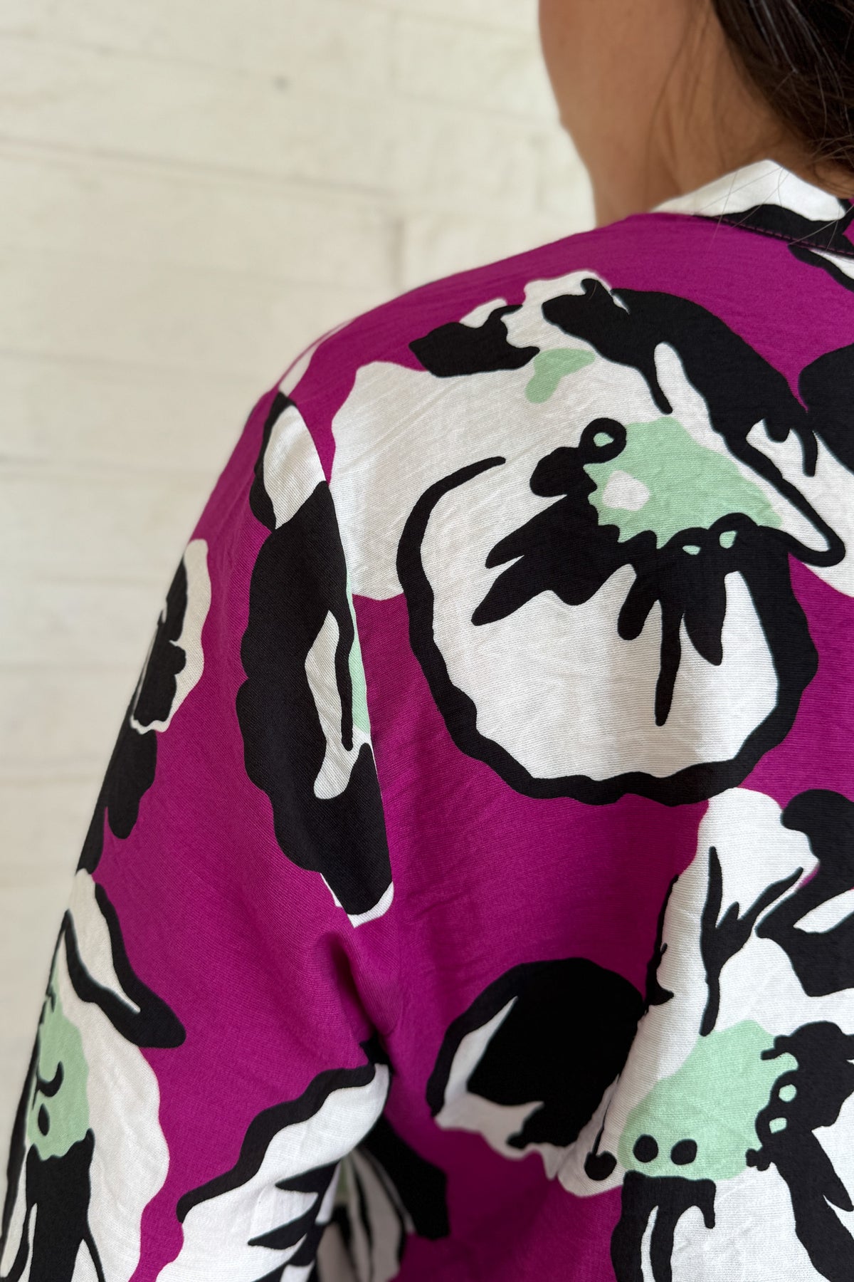 Designed in Spain, this bold floral blouse makes a statement with its vibrant magenta base and oversized poppy print. The lightweight viscose blend drapes beautifully, giving it a relaxed yet refined look. Perfect for pairing with black denim or trousers, it’s an easy way to add color and personality to your everyday style.
