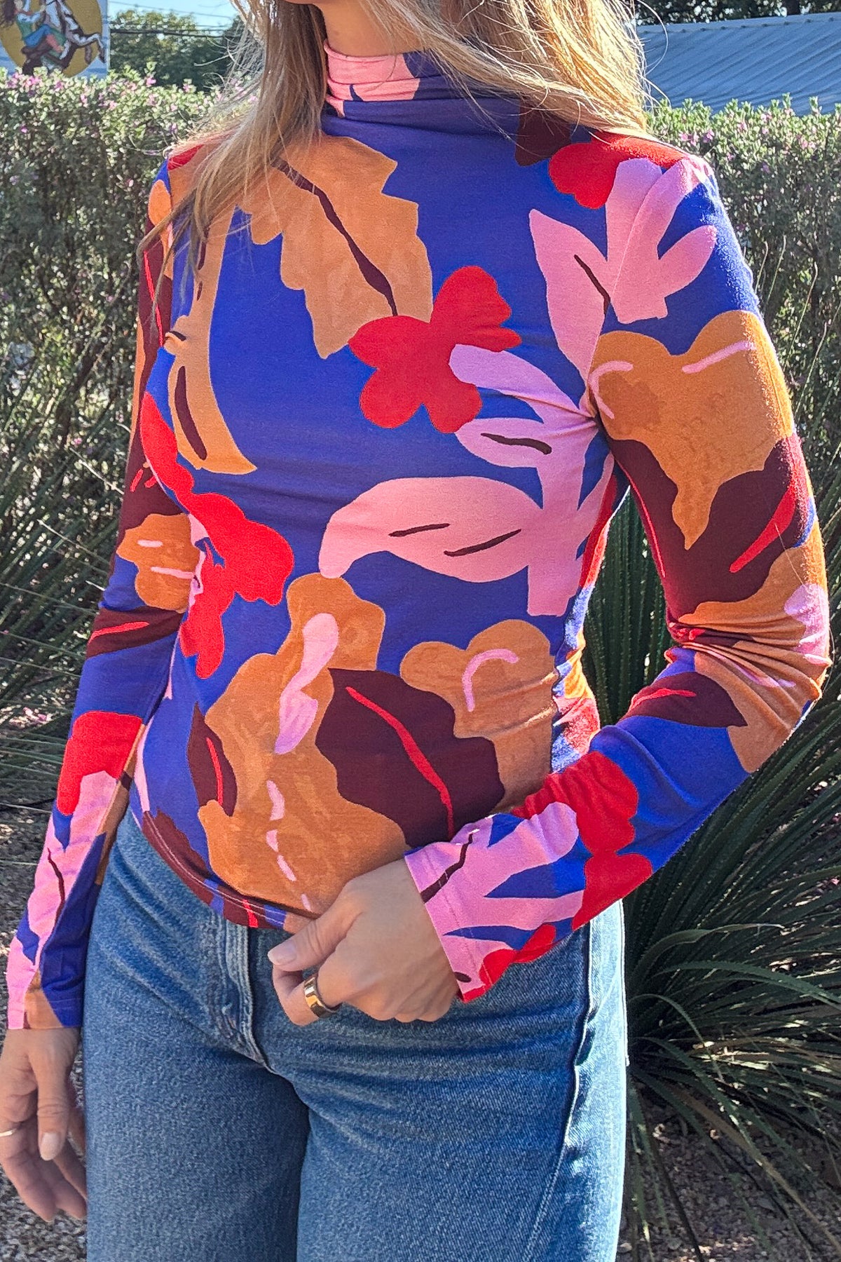 Women's printed mock neck top styled with blue denim jeans for an effortless everyday outfit. Shop Cotton & Cashmere in Blanco, Texas.