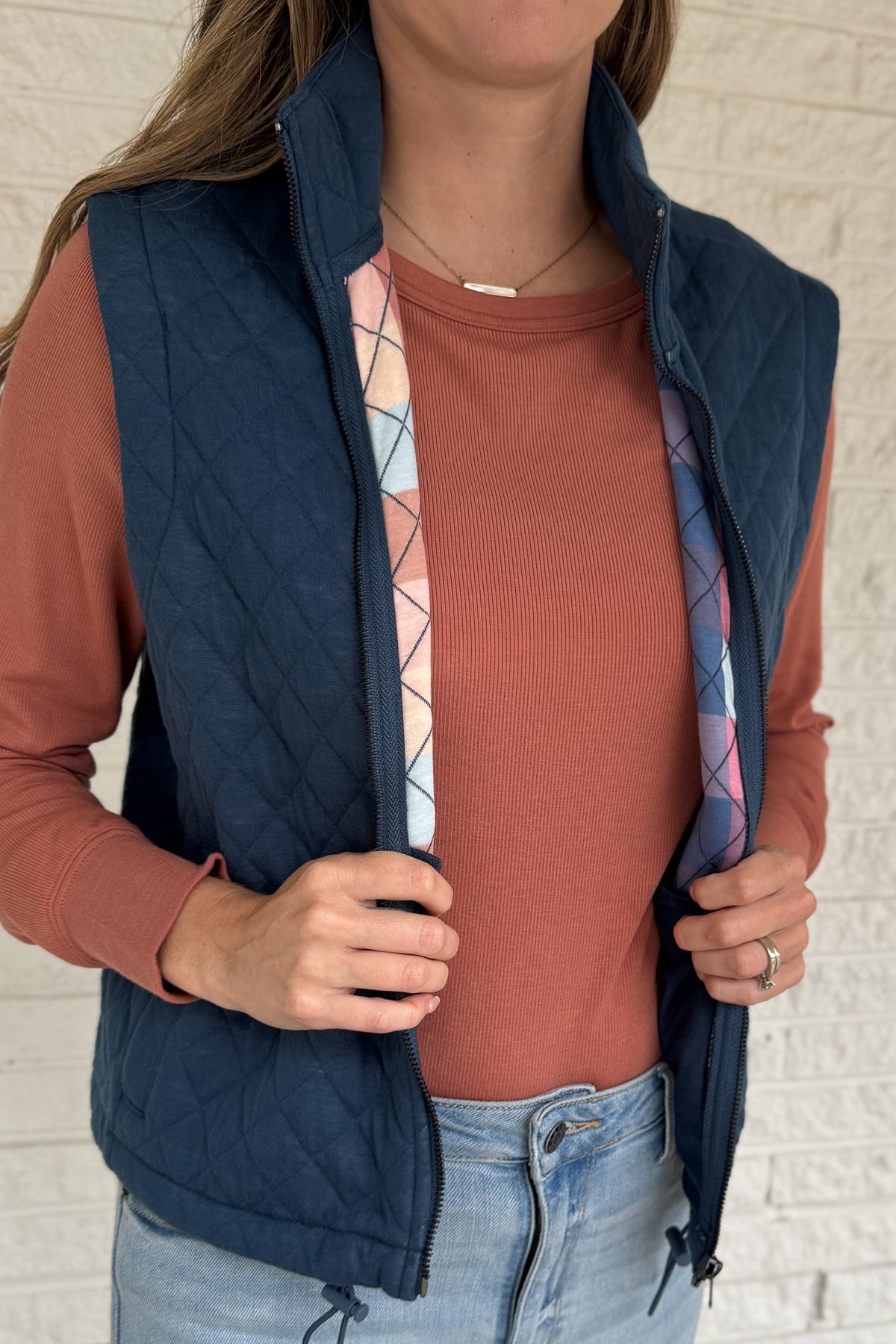 This quilted vest brings effortless layering to your everyday style. Designed in a classic navy hue with soft diamond stitching, it’s the perfect blend of warmth and versatility. The inside reveals a fun pop of color with a geometric print lining—making it just as cute zipped up as it is open.