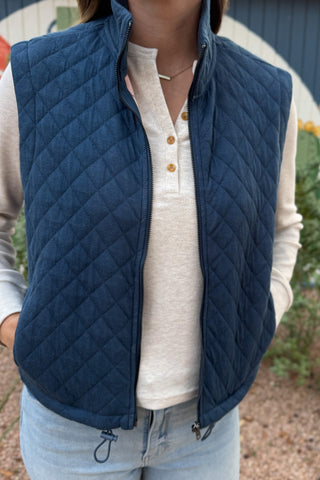 This quilted vest brings effortless layering to your everyday style. Designed in a classic navy hue with soft diamond stitching, it’s the perfect blend of warmth and versatility. The inside reveals a fun pop of color with a geometric print lining—making it just as cute zipped up as it is open.