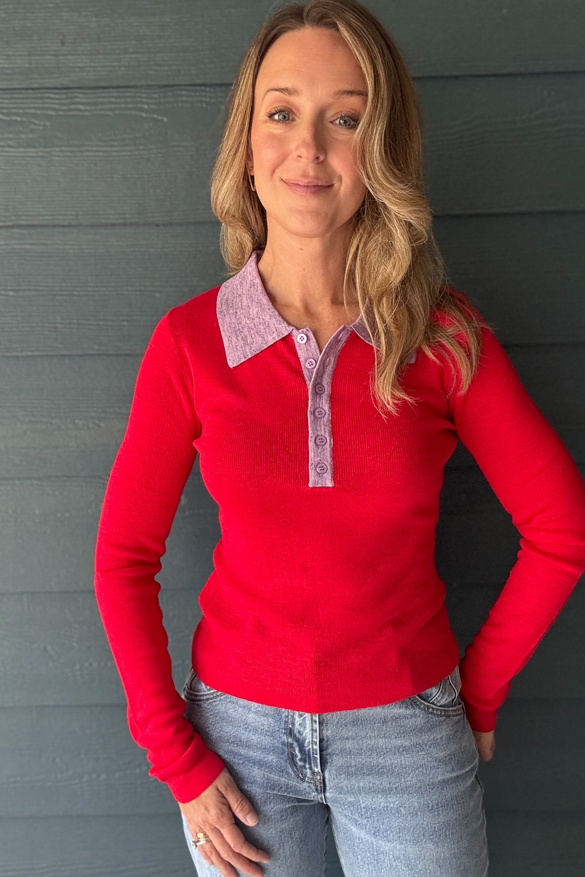 Detail view of women’s red knit polo sweater featuring a lavender collar, tonal buttons and soft fine knit texture.