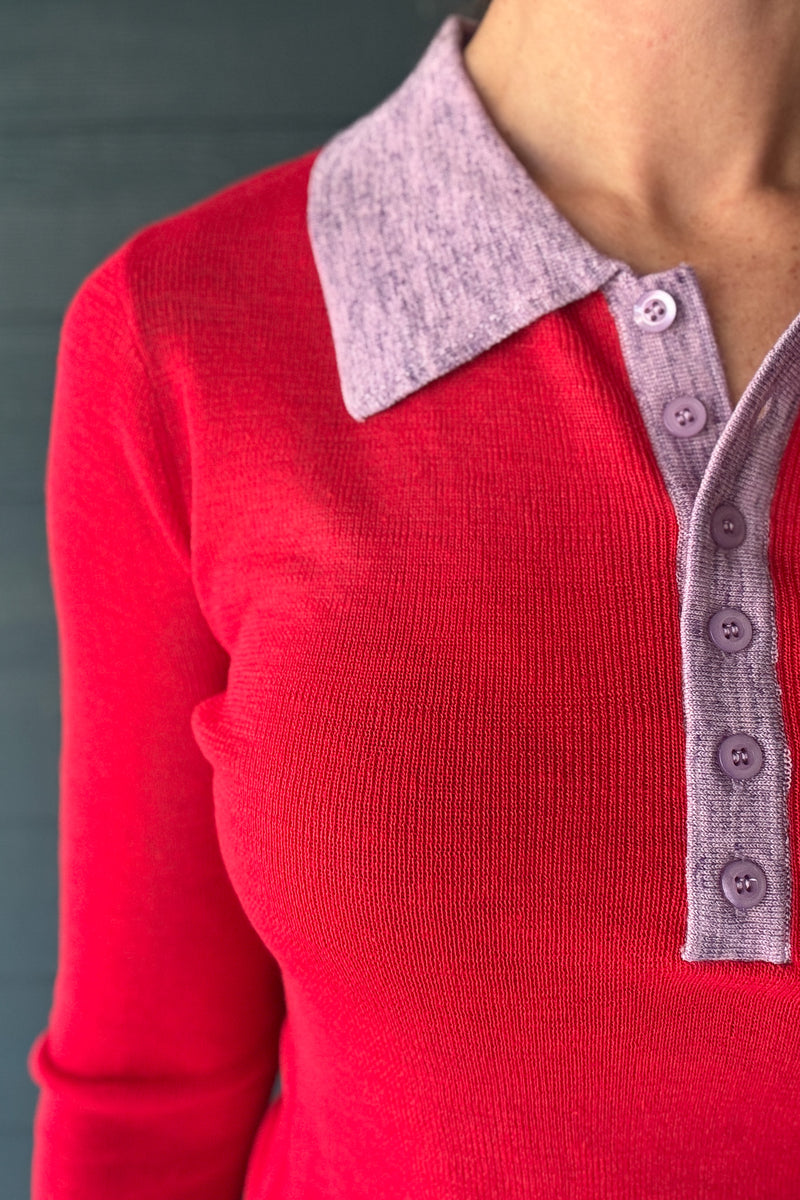 Side view of women’s red long sleeve knit polo sweater with contrast lavender collar and slim fitted silhouette.