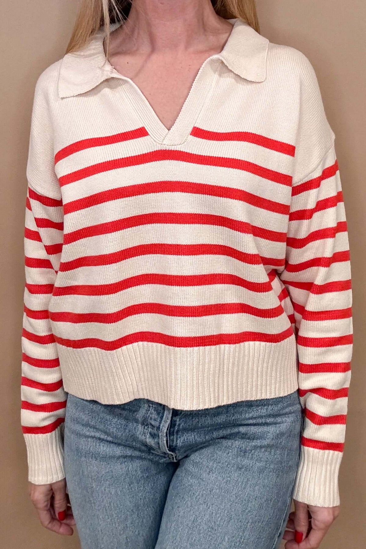 Effortlessly stylish, the Preppy Sweater in red and cream stripes is a must-have for any fashion-forward individual. Featuring a split neck with collar and hitting at the hip line, this sweater is perfect for a casual yet put-together look. Pair it with your favorite denim for an easy, on-the-go outfit.