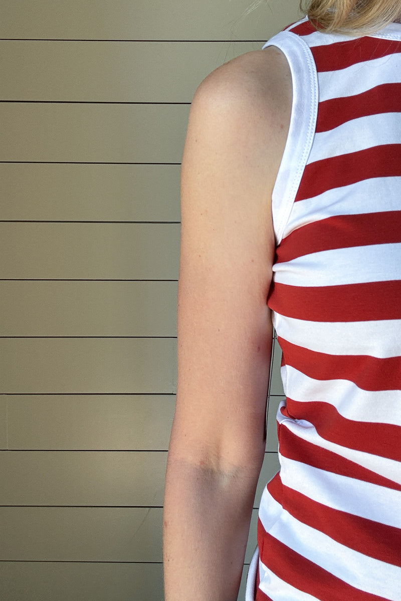 The Classic Red &amp; White Striped Tank is a must-have staple for effortless, everyday style. Made from a soft and breathable blend of 98% cotton and 2% spandex, this tank offers the perfect amount of stretch while maintaining its structured shape. The bold red and white stripes bring a timeless, nautical-inspired vibe, making it an easy go-to for warm days and layering.