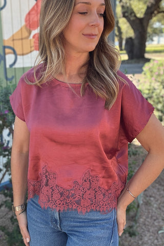 Dusty pink short sleeve blouse for women featuring a silky satin finish, loose silhouette, and sheer floral lace trim. Shop effortless women's fashion at Cotton & Cashmere Boutique.