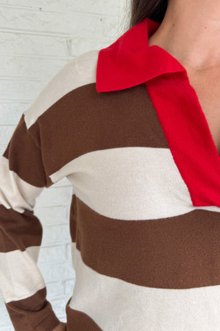 &nbsp;A sporty twist on classic prep, this rugby-style sweater is made for everyday wear with effortless clothing appeal. Featuring bold brown and cream stripes with a pop of red at the collar and neckline, it brings casual comfort with a standout edge. The mid-weight knit feels soft yet structured, perfect for layering or wearing solo.
