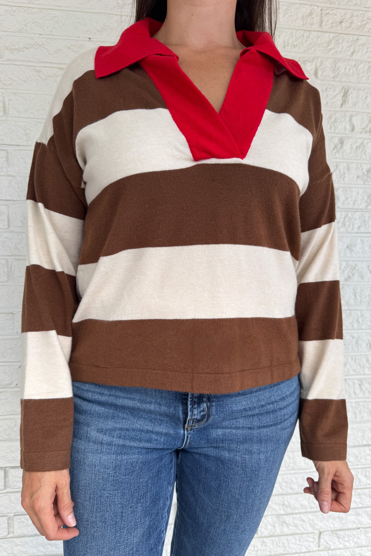 &nbsp;A sporty twist on classic prep, this rugby-style sweater is made for everyday wear with effortless clothing appeal. Featuring bold brown and cream stripes with a pop of red at the collar and neckline, it brings casual comfort with a standout edge. The mid-weight knit feels soft yet structured, perfect for layering or wearing solo.